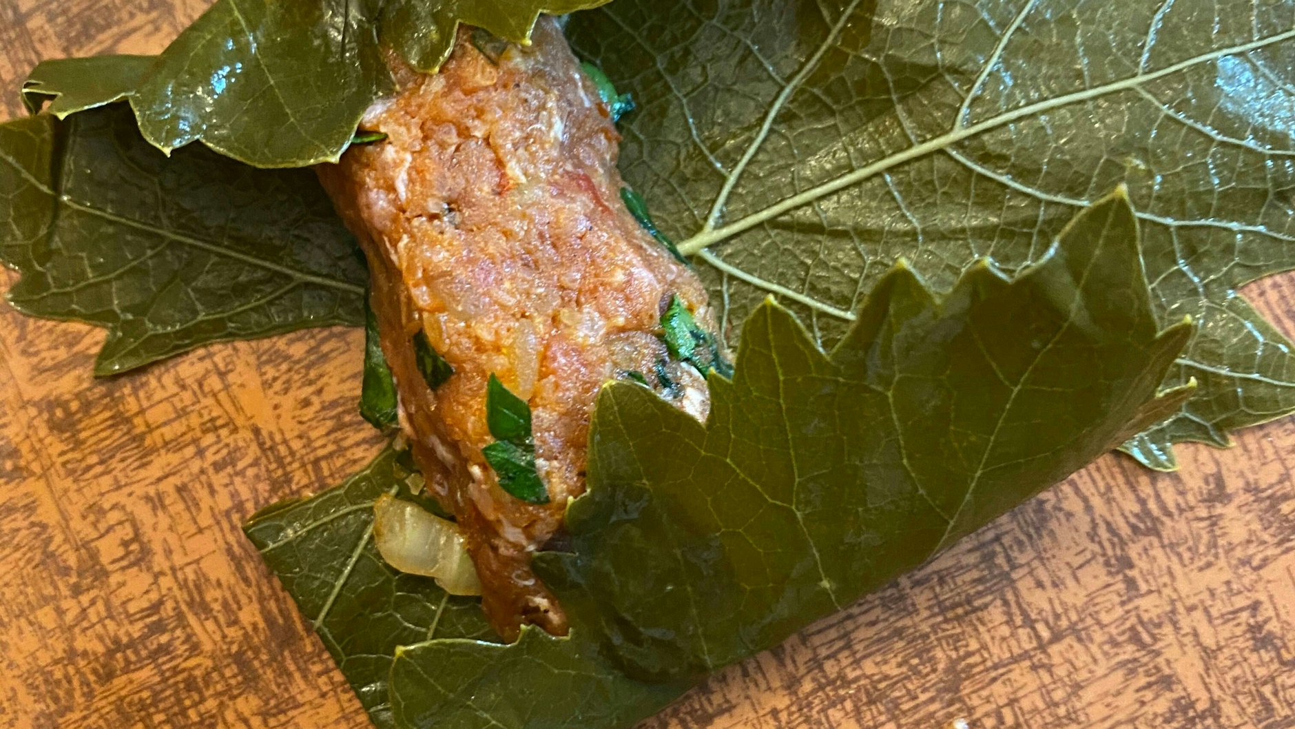 So wird das Weinblatt gerollt: Erst werden die Seiten engeschlagen, dann wird es von unten aufgerollt.