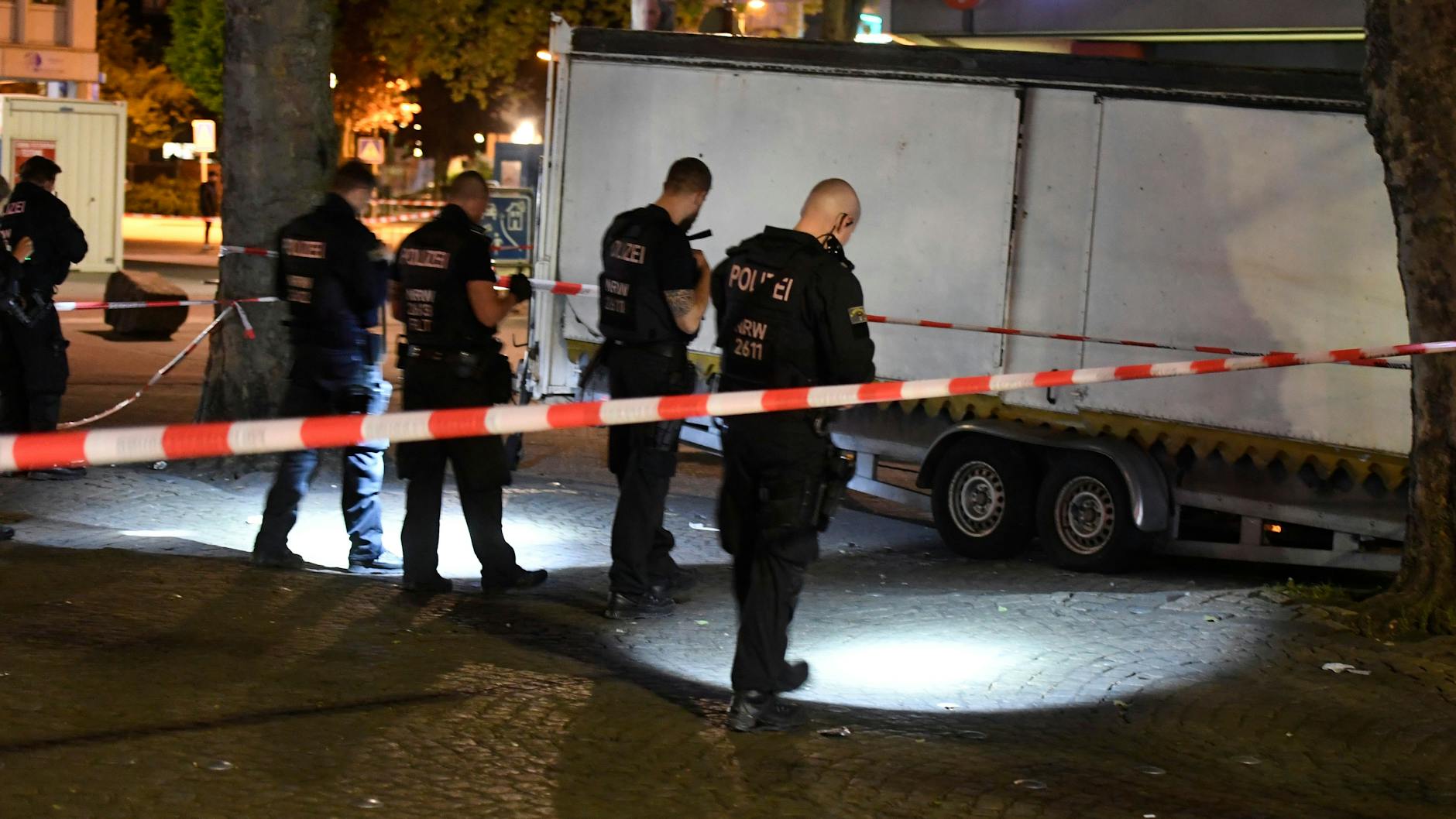 Polizisten suchen in der Nacht nach Spuren der Schießerei auf dem Hamborner Altmarkt in Duisburg.