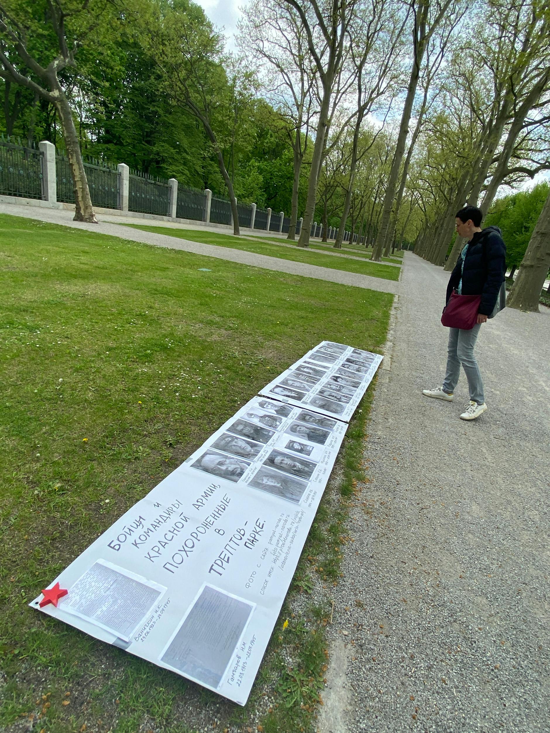 Elena schaut auf die Fotos einzelner im Treptower Park begrabenen Soldaten.