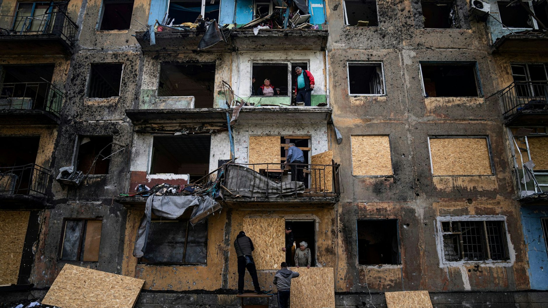Zerstörtes Gebäude in Dobropillja in der Donezk-Region. Menschen sichern ihre Fenster provisorisch mit Holzplatten.