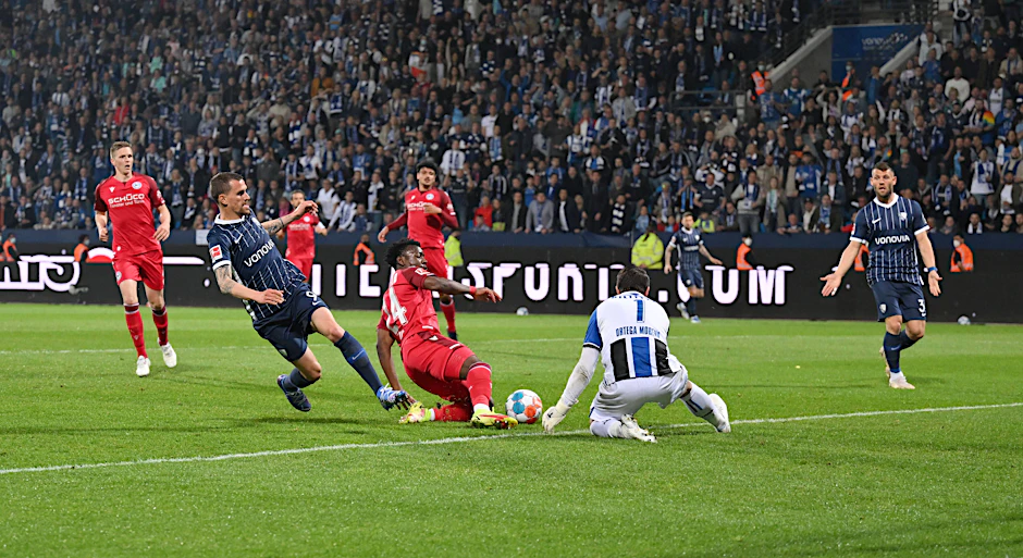Bochums Zoller schießt, Bielefelds Keeper Ortega lässt den Ball abprallen und das Leder springt von Bellos Knie ins Arminen-Tor zum 1:2