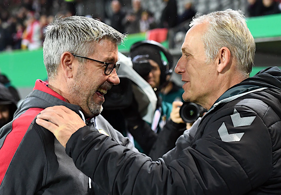 Unions Trainer Urs Fischer im freundlichen Austausch mit Freiburgs Coach Christian Streich (r.).