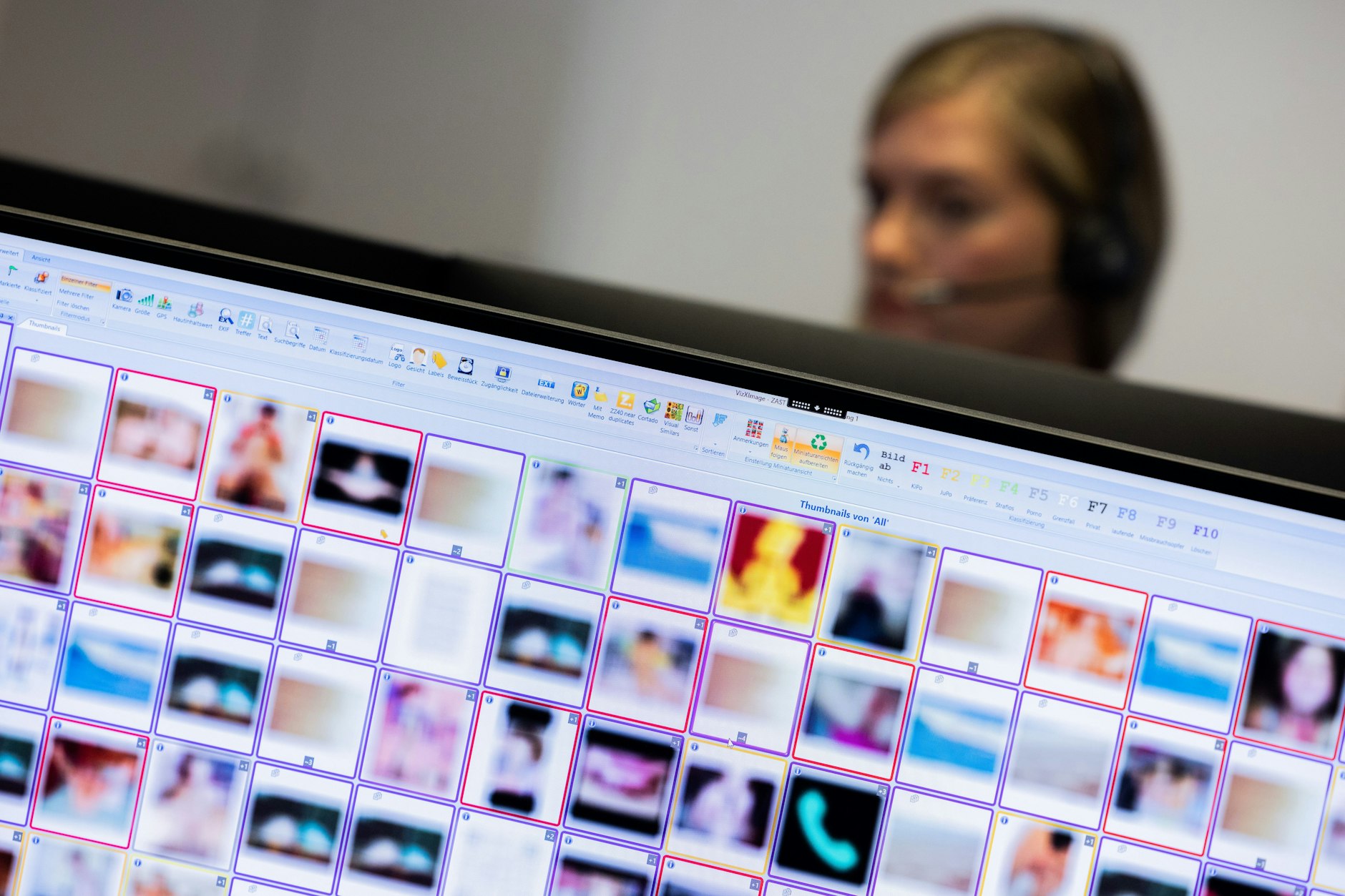 Eine Ermittlerin sitzt vor Monitoren mit unkenntlich gemachten Fotografien, die teilweise sexuellen Missbrauch zeigen.