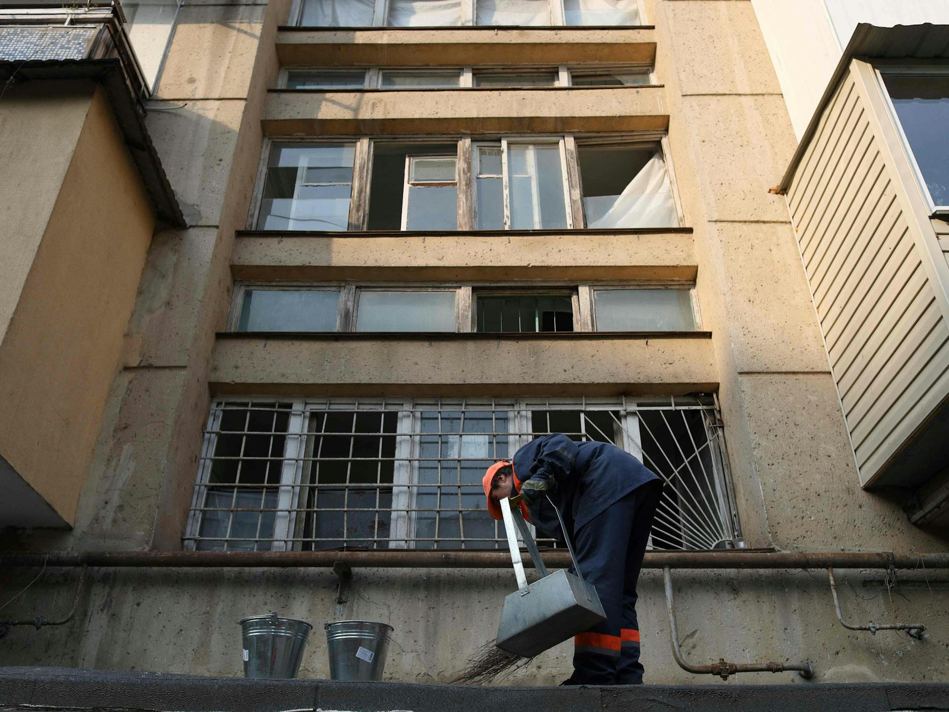 Ein Arbeiter der Stadtreinigung kehrt Scherben und Schutt nach dem Raketenangriff in Odessa auf.