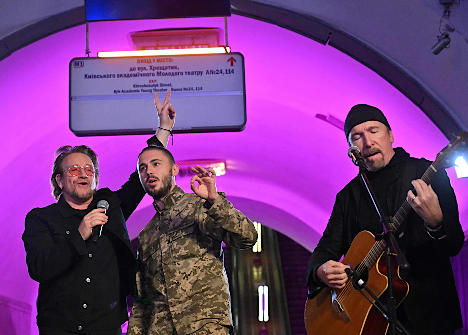 Bono (l.) und The Edge (r.) in Kiew. Sie hatten sich einen ukrainischen Soldaten auf ihre improvisierte Bühne geholt.