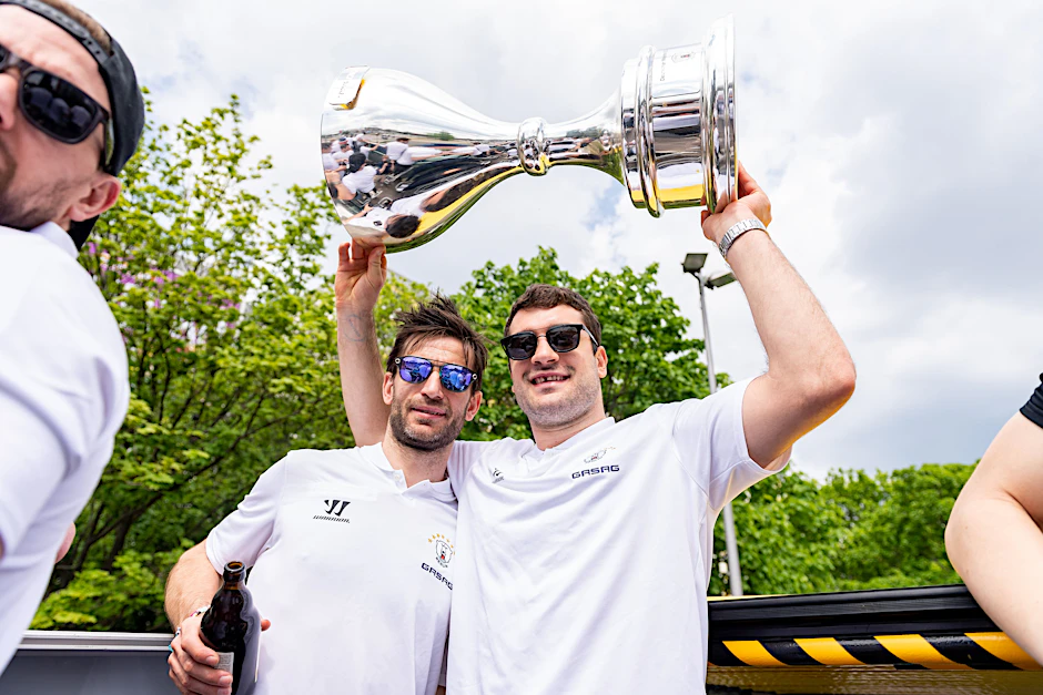 Frans Nielsen (l.) genießt bei der Saisonabschlussfeier seinen letzten Auftritt als Eisbär in Berlin, Giovanni Fiore hält ihm den Meister-Pokal.