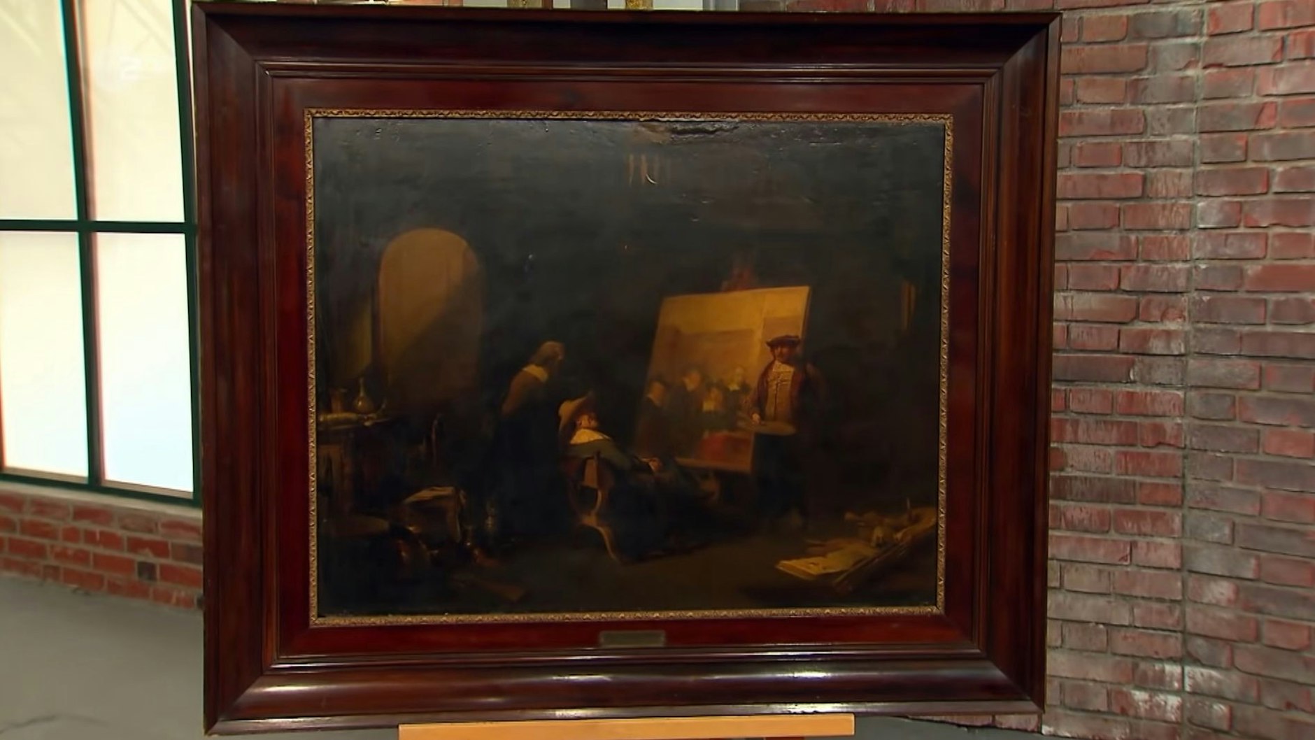 Das Bild bei „Bares für Rares“ zeigt eine Szene, in der Rembrandt in seinem Atelier neben seinem unvollendeten Bild der Tuchmacherzunft steht.