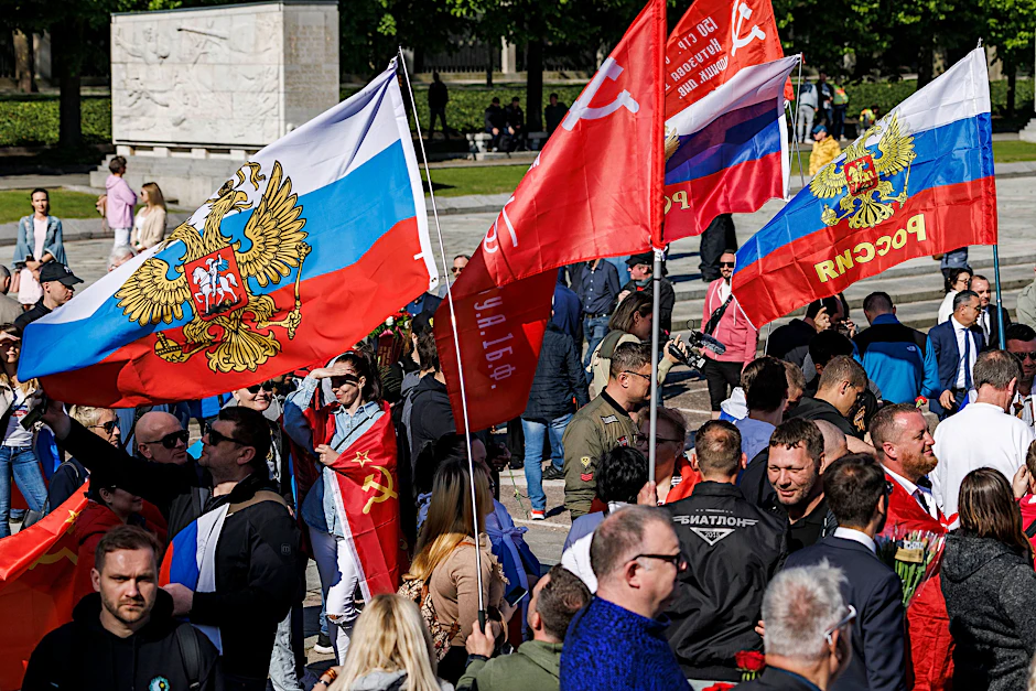 Menschen schwenken bei einer Gedenkveranstaltung am sowjetischen Ehrenmal im Treptower Park russische und sowjetische Fahnen.