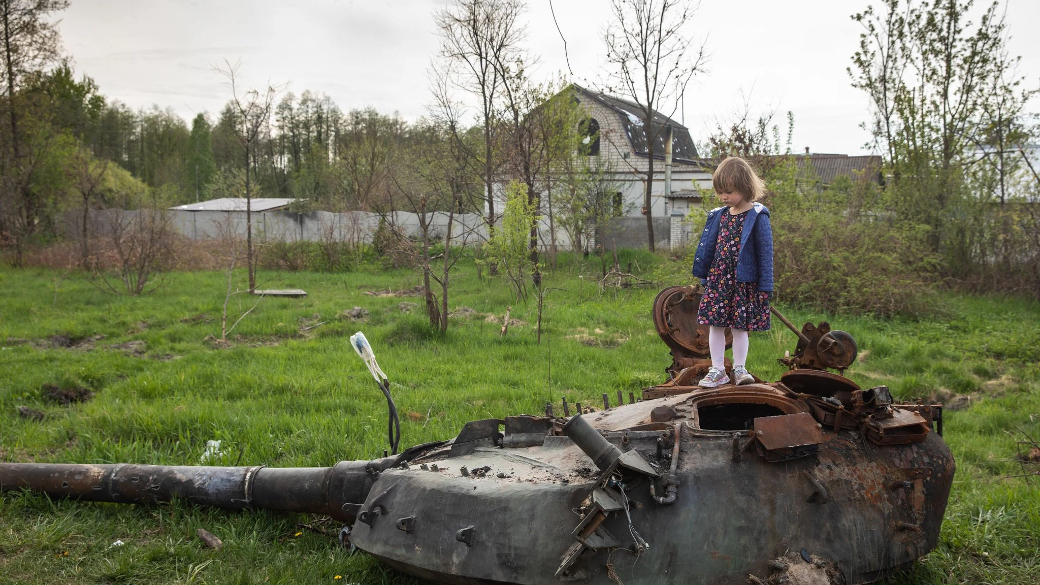 Ein Mädchen steht auf dem Turm eines zerstörten russischen Panzers in einem Dorf nahe Kiew. 