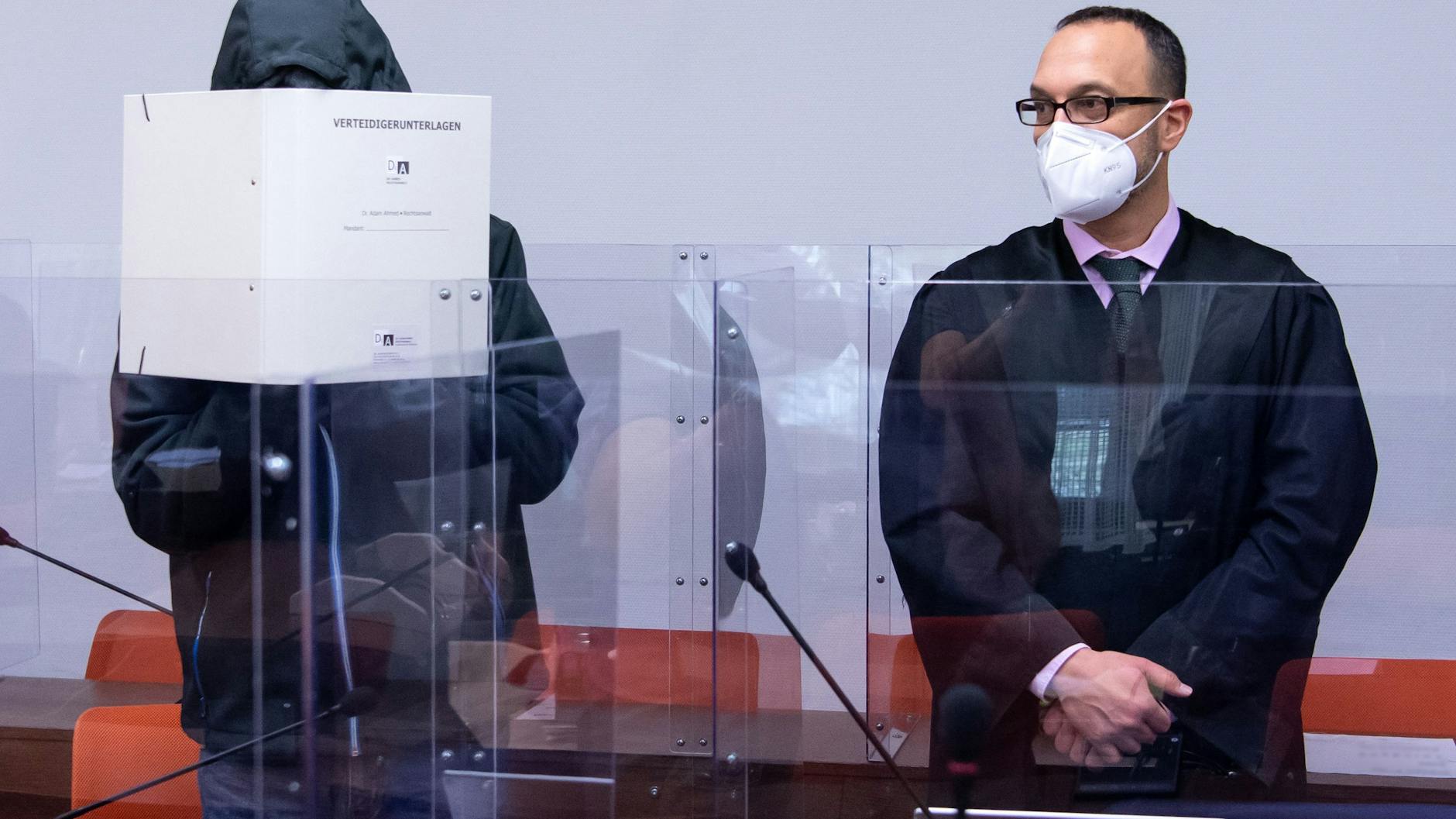 Der wegen schweren sexuellen Missbrauchs angeklagte Mann (l) steht vor Prozessbeginn im Landgericht neben seinem Anwalt Adam Ahmed im Verhandlungssaal.