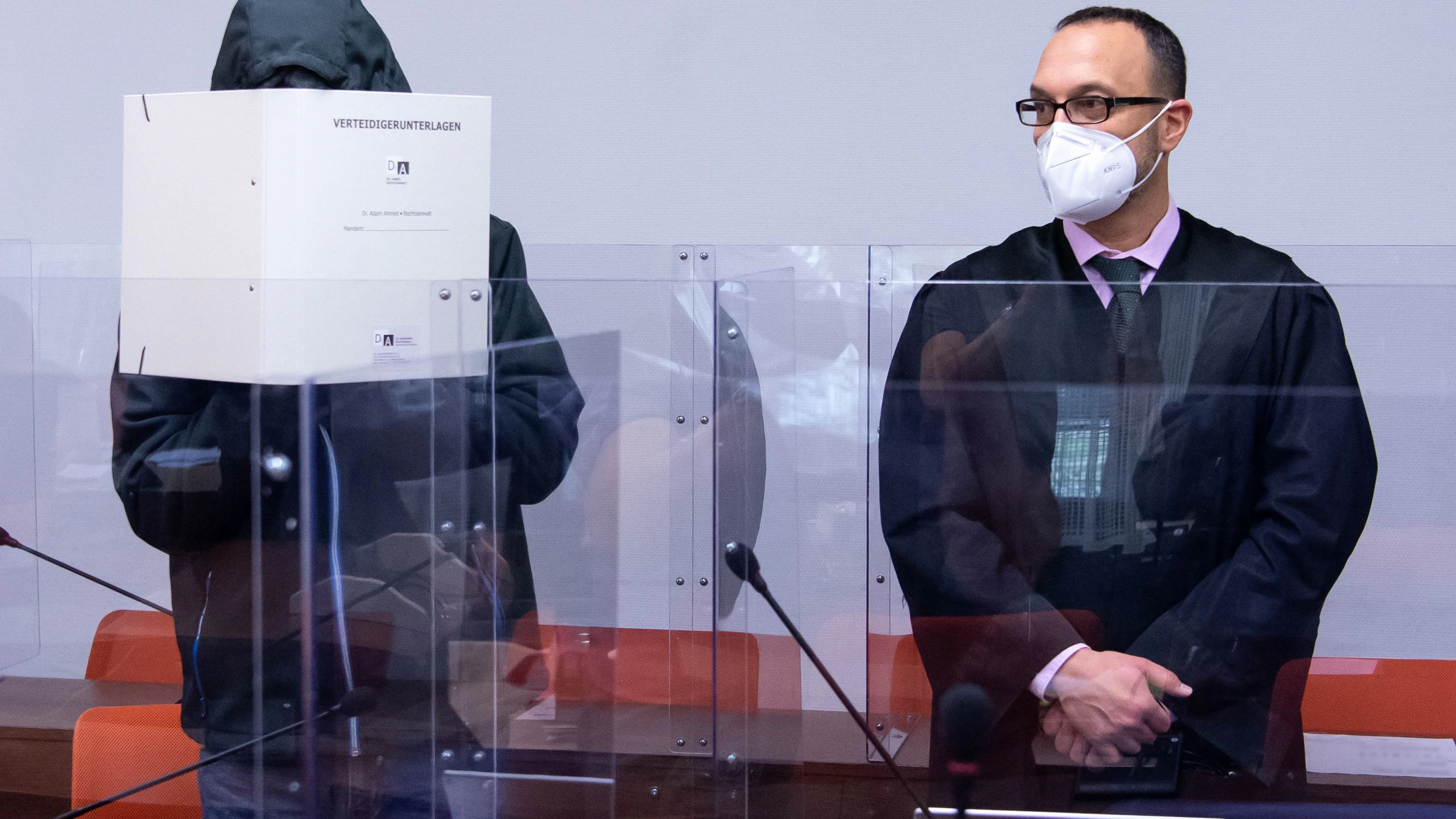 Der wegen schweren sexuellen Missbrauchs angeklagte Mann (l) steht vor Prozessbeginn im Landgericht neben seinem Anwalt Adam Ahmed im Verhandlungssaal.
