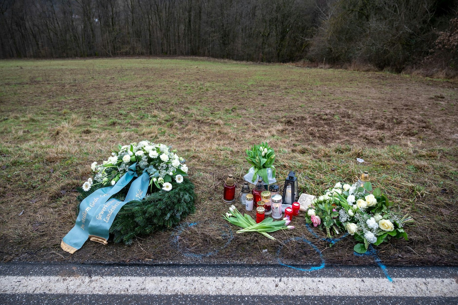 Ein Kranz, Blumen und Kerzen liege im Februar an einem Tatort nahe Kusel in der Pfalz. Hier waren die zwei Polizisten erschossen worden.