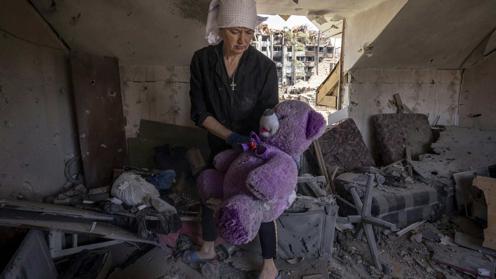 Svetlana Magyrovks, 58, holt einen riesigen lila Teddybären in einem Zimmer ihres Hauses, nachdem Russen Anfang März in Irpin die Nachbarschaft beschossen hatten.