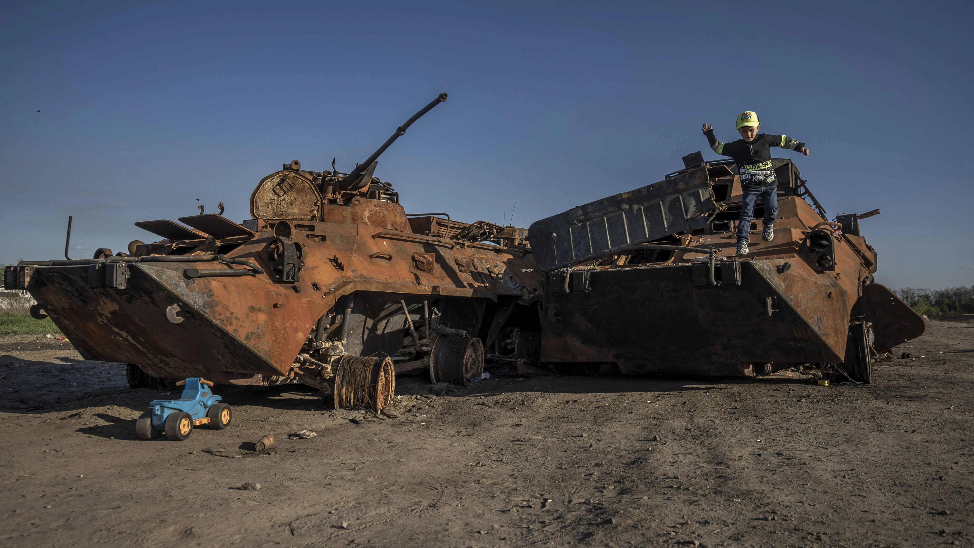 Ein kleiner Junge spielt auf einem ausgebrannten russischen Panzer, der auf einem provisorischen Parkplatz in der Nähe von Irpin, Ukraine, abgestellt wurde. 
