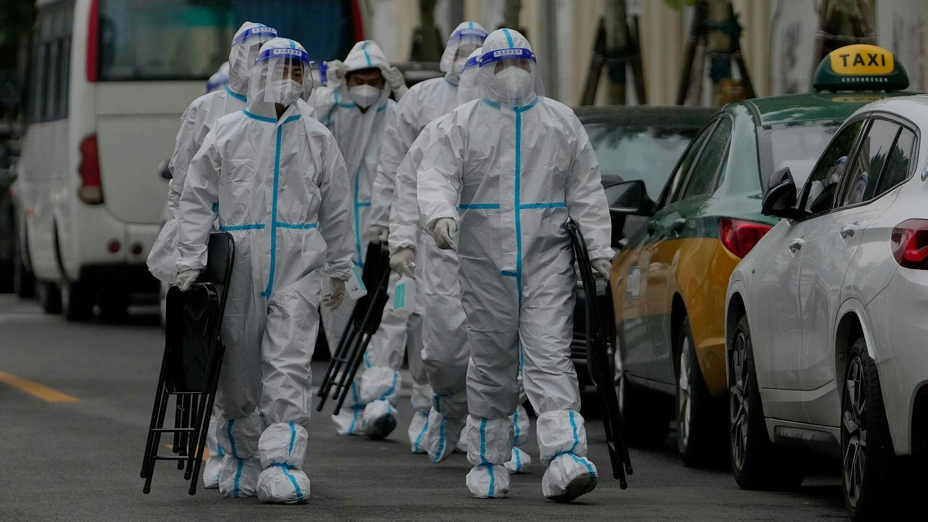 Arbeiter des Gesundheitswesens sind auf dem Weg zu einem abgesperrten Wohnkomplex in Peking.