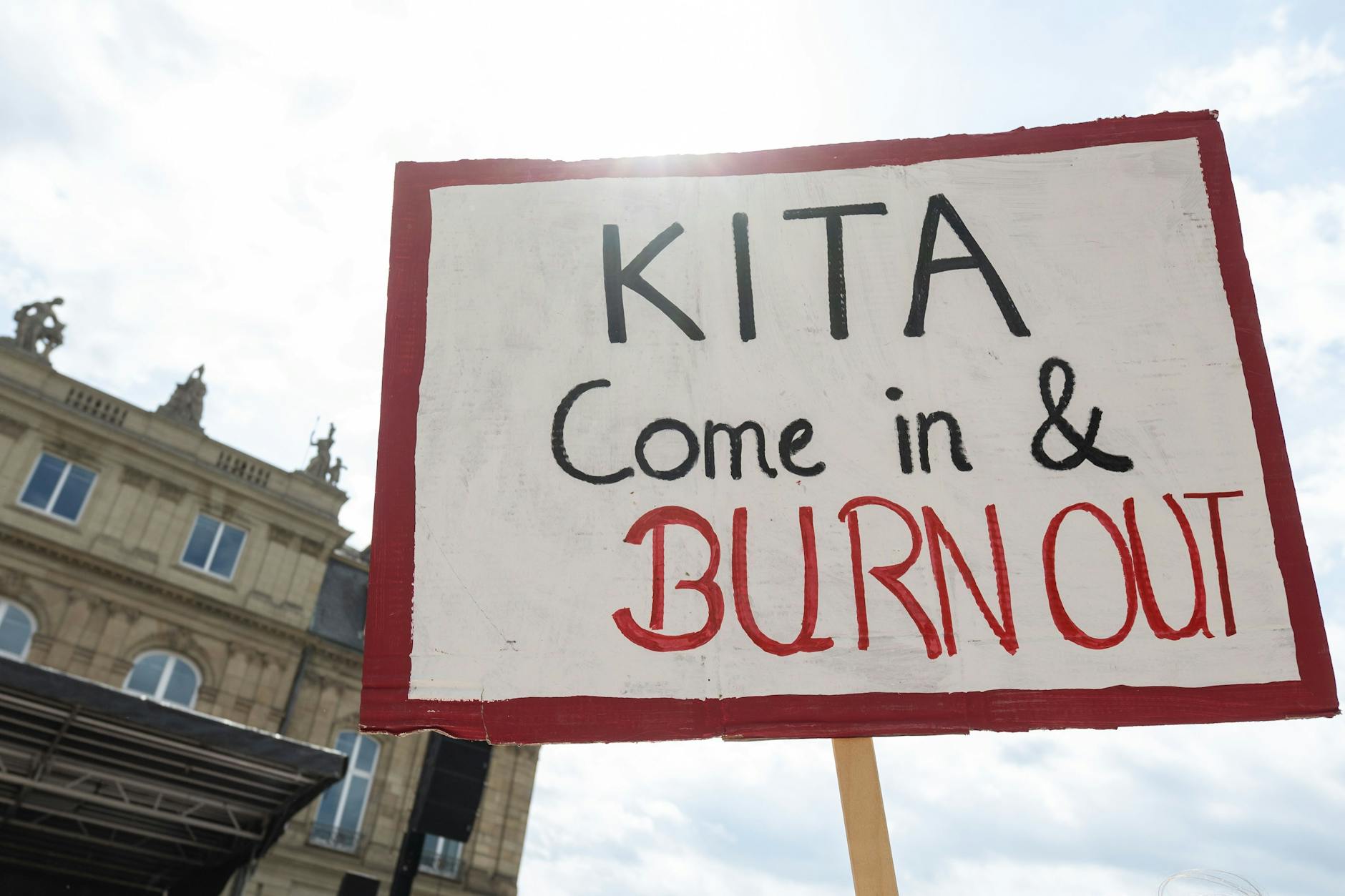 Ein Plakat mit der Aufschrift Kita Come in & Burn Out ist während einer Demonstration vor dem baden-württembergischen Finanzministerium zu sehen. Die Gewerkschaft Verdi hat zu einem landesweiten Aktionstag mit Warnstreiks im Sozial- und Erziehungsdienst aufgerufen.