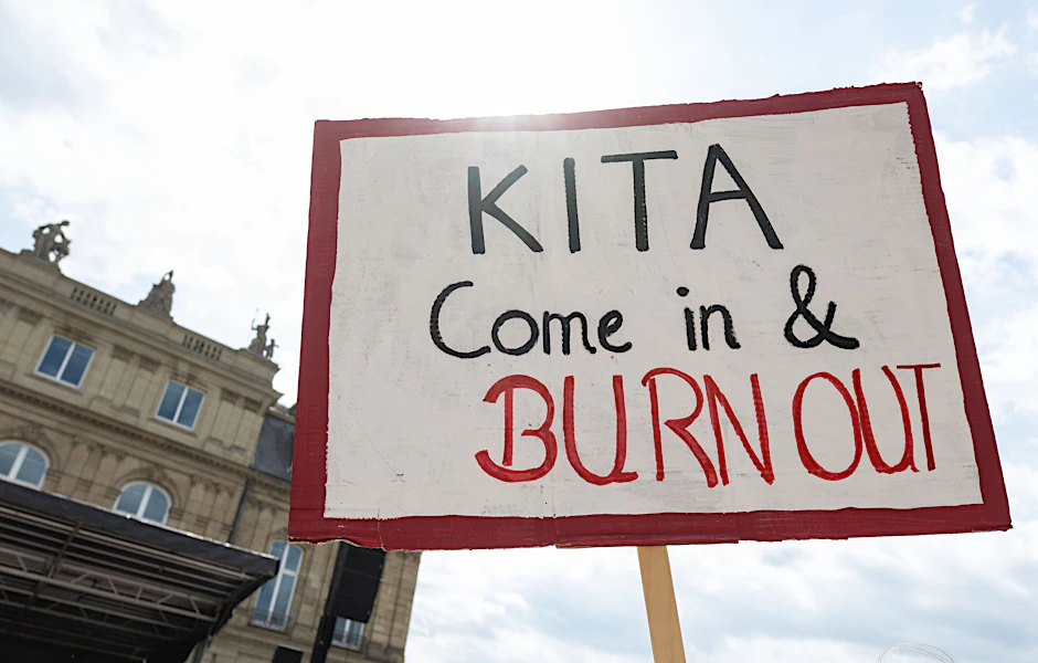 Ein Plakat mit der Aufschrift Kita Come in &amp; Burn Out ist während einer Demonstration vor dem baden-württembergischen Finanzministerium zu sehen. Die Gewerkschaft Verdi hat zu einem landesweiten Aktionstag mit Warnstreiks im Sozial- und Erziehungsdienst aufgerufen.