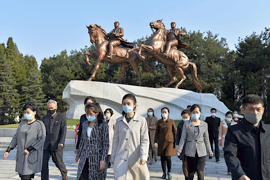 Menschen laufen mit Masken durch Pjöngjang. In der Hauptstadt Nordkoreas seien die ersten Corona-Fälle registriert worden.