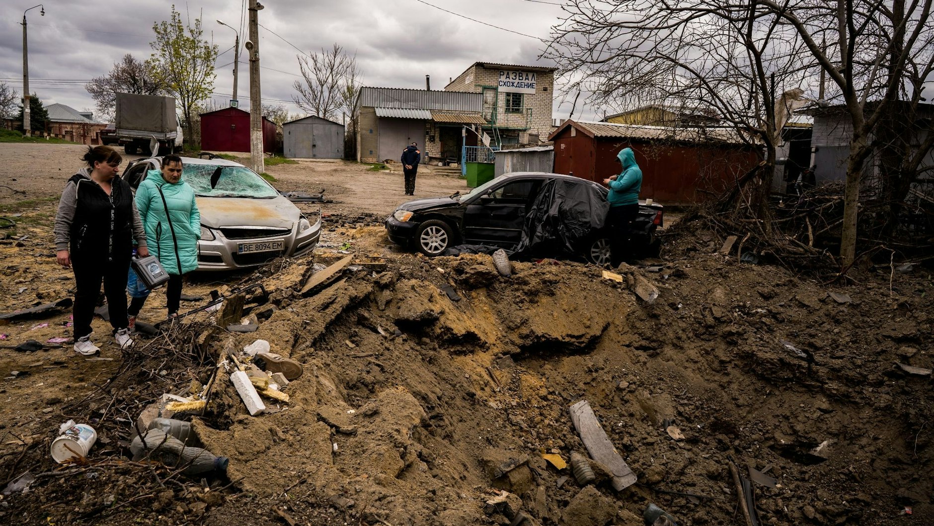 Zwei Frauen betrachten den Krater, den eine russische Rakete in einem Wohnviertel in Mykolajiw hinterlassen hat (Archivfoto).