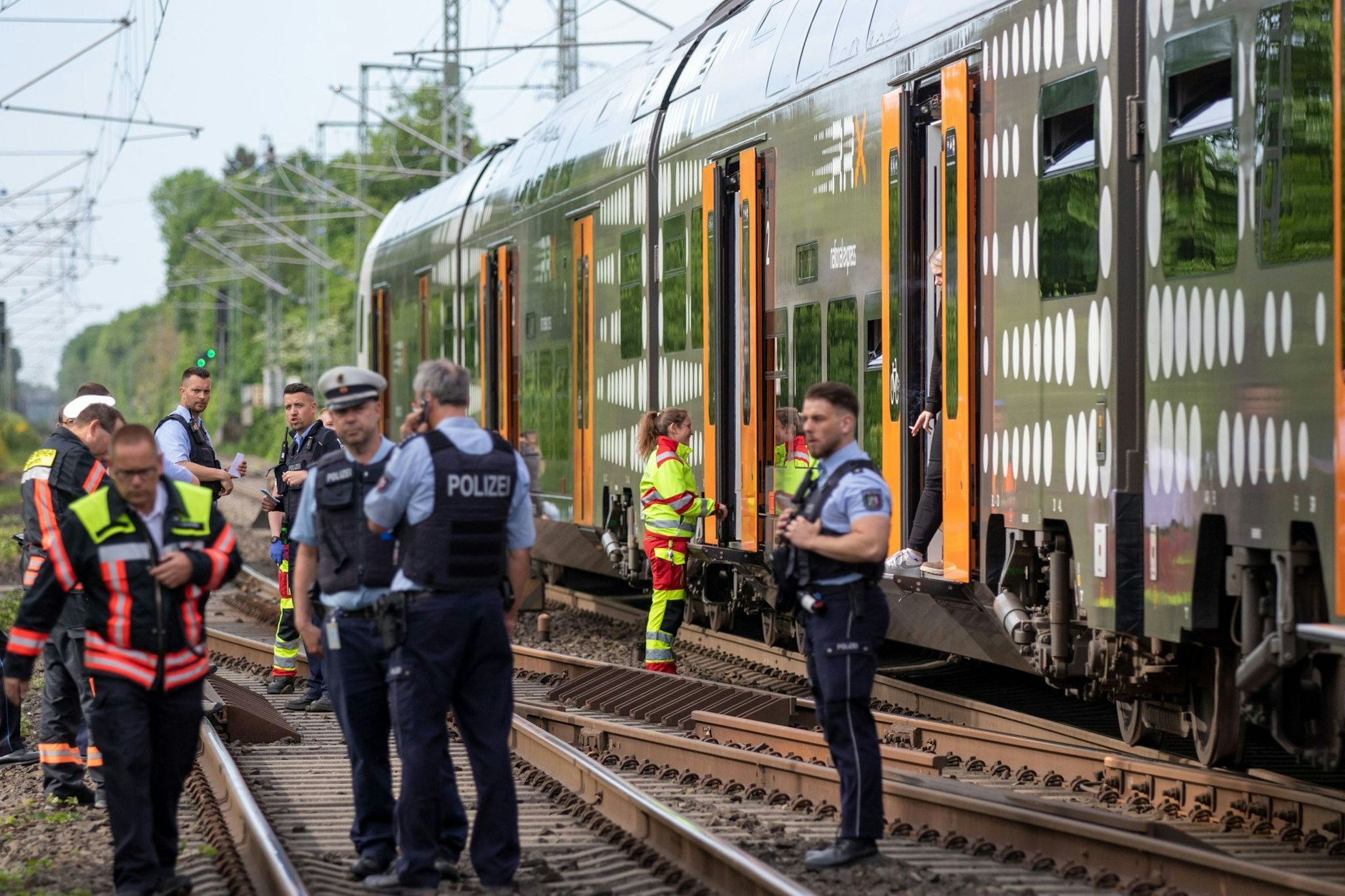 Polizisten stehen vor der Regionalbahn, in der sich die Attacke ereignete.