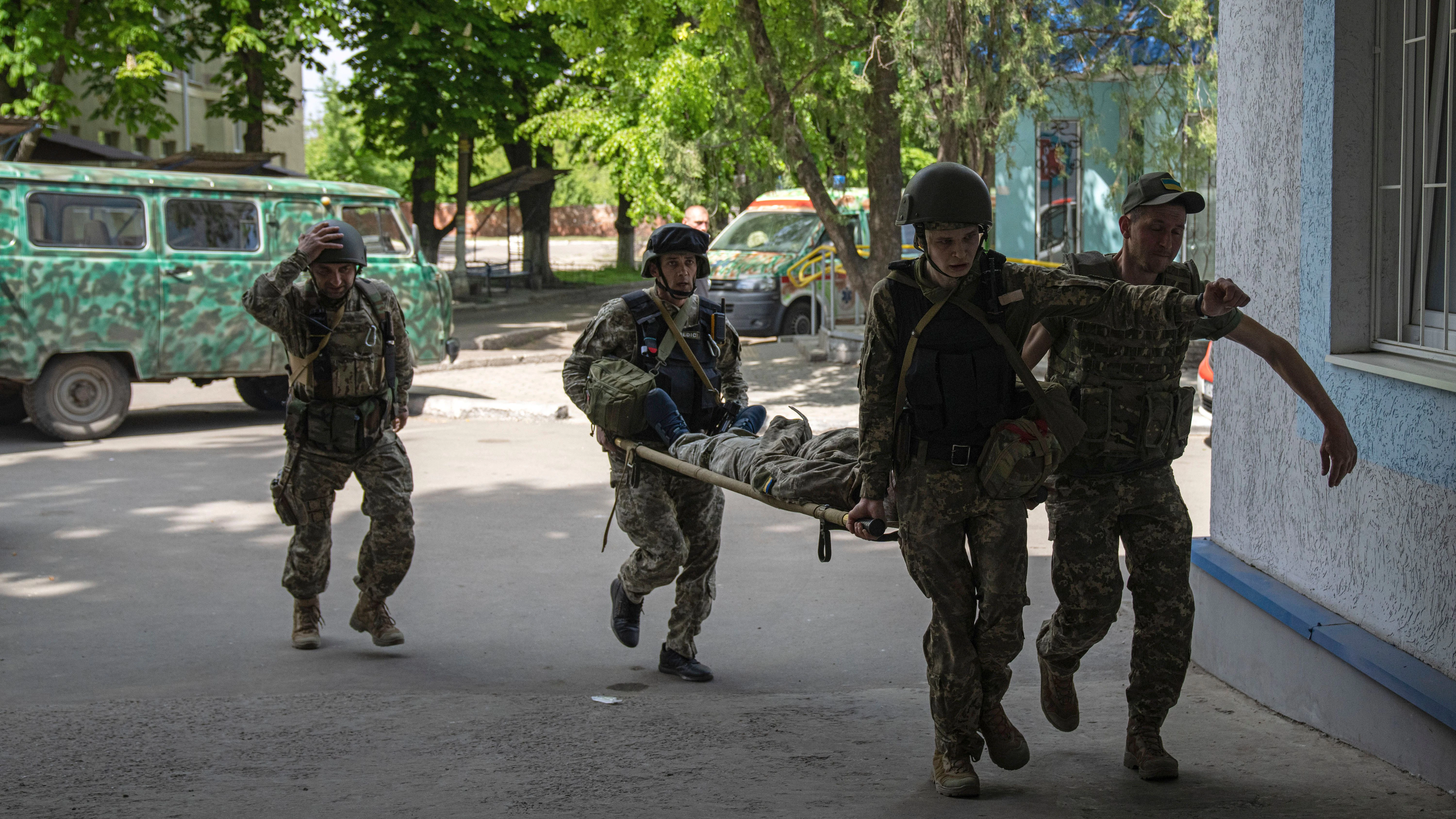 Ukrainische Soldaten bringen einen verwundeten Kameraden in Sicherheit.