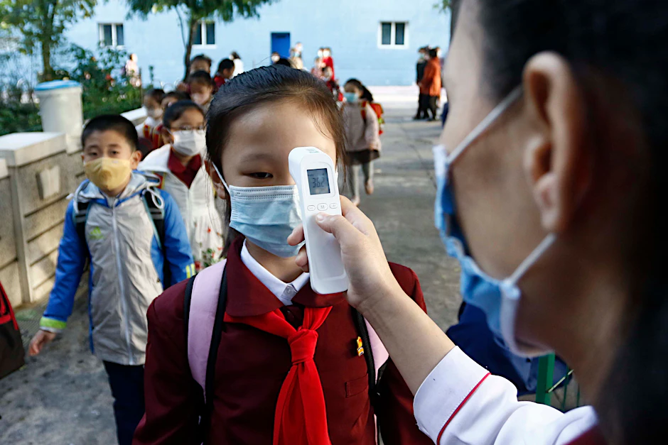 Pjöngjang: Eine Lehrerin misst die Körpertemperatur einer Schülerin, bevor sie die Kim-Song-Ju-Grundschule im Zentralbezirk betritt.