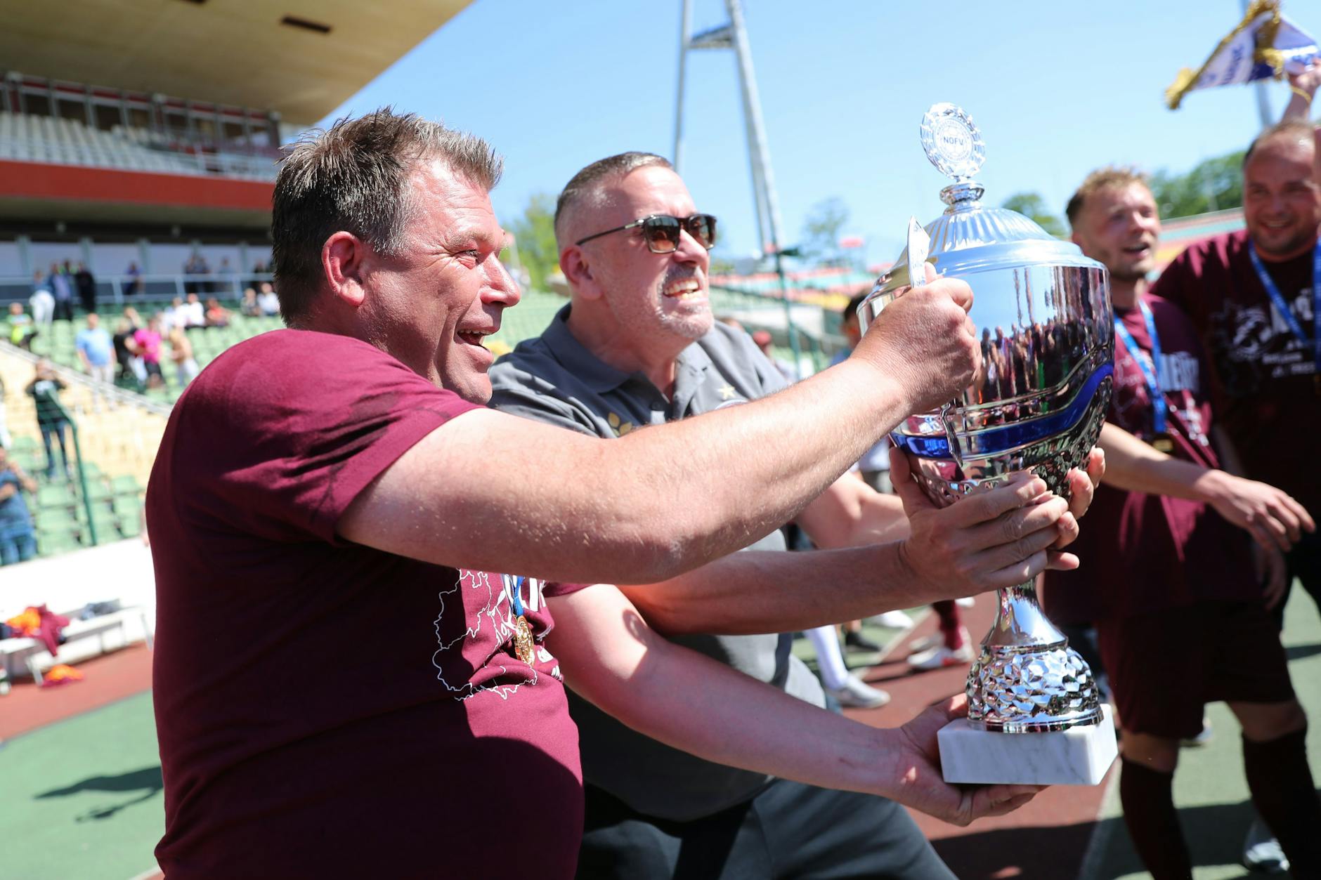 Oh, wie ist der schön! BFC-Trainer Christian Benbennek und Dynamo-Boss Peter Meyer stemmen die Meistertrophäe der Regionalliga in die Höhe.