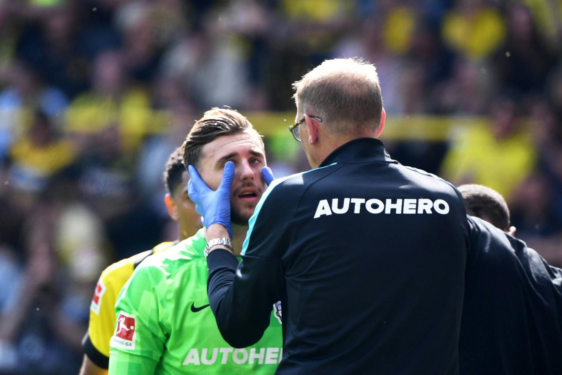 Torhüter Marcel Lotka wurde nach seinem Pfosten-Crash in Dortmund von Mannschaftsarzt Dr. Ulrich Schleicher sofort behandelt.