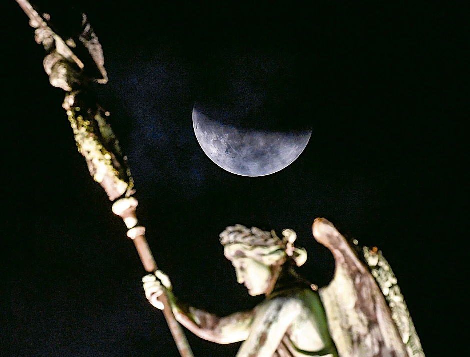 Der Mond ist während einer partiellen Mondfinsternis hinter der Quadriga des Brandenburger Tors zu sehen.