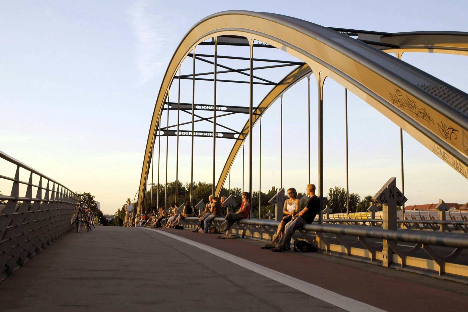 Junge Leute genießen die Abendstimmung auf der Modersohnbrücke in Berlin-Friedrichshain.
