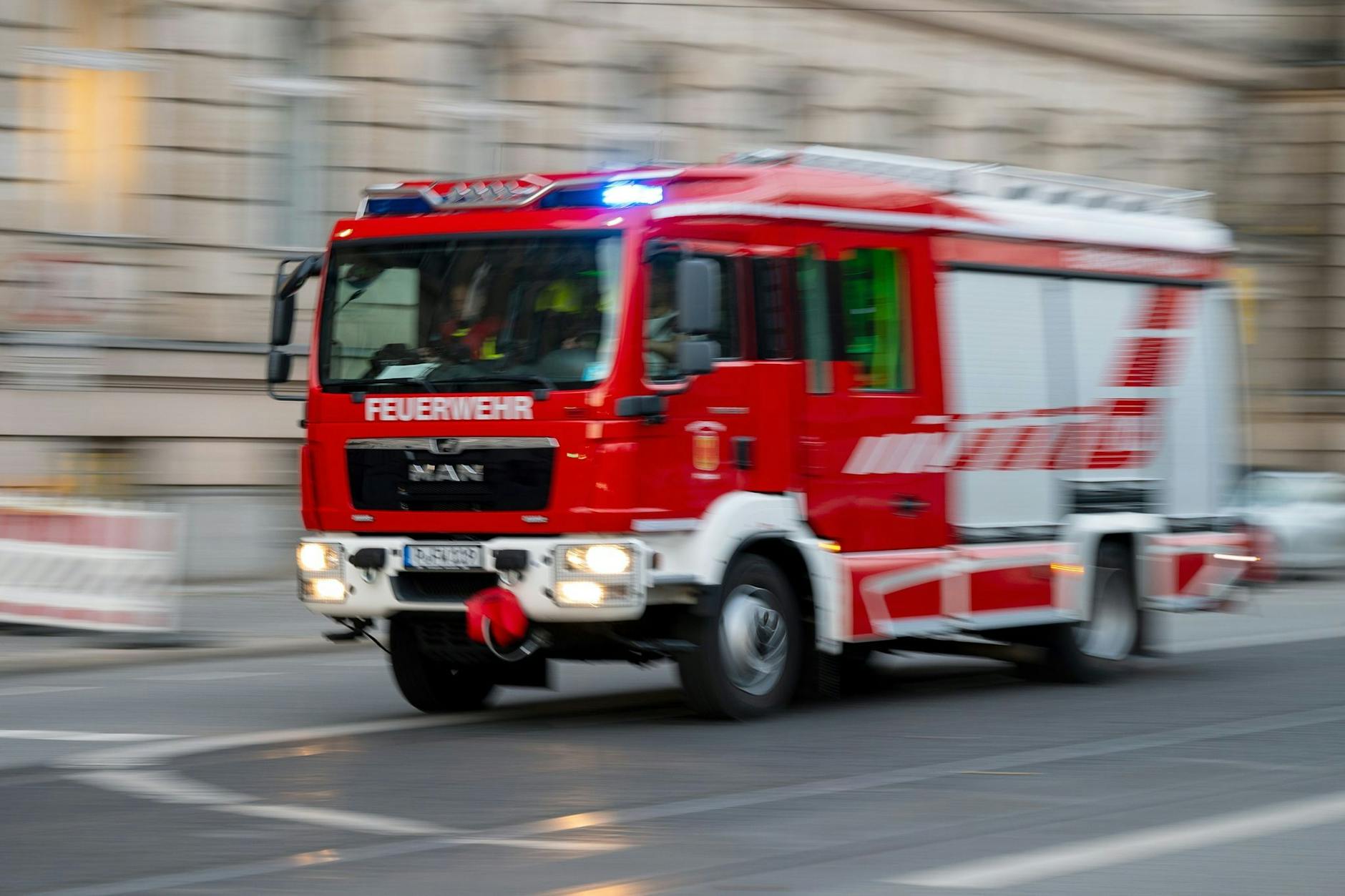 Ein Feuerwehrfahrzeug ist mit Blaulicht auf Einsatzfahrt. 