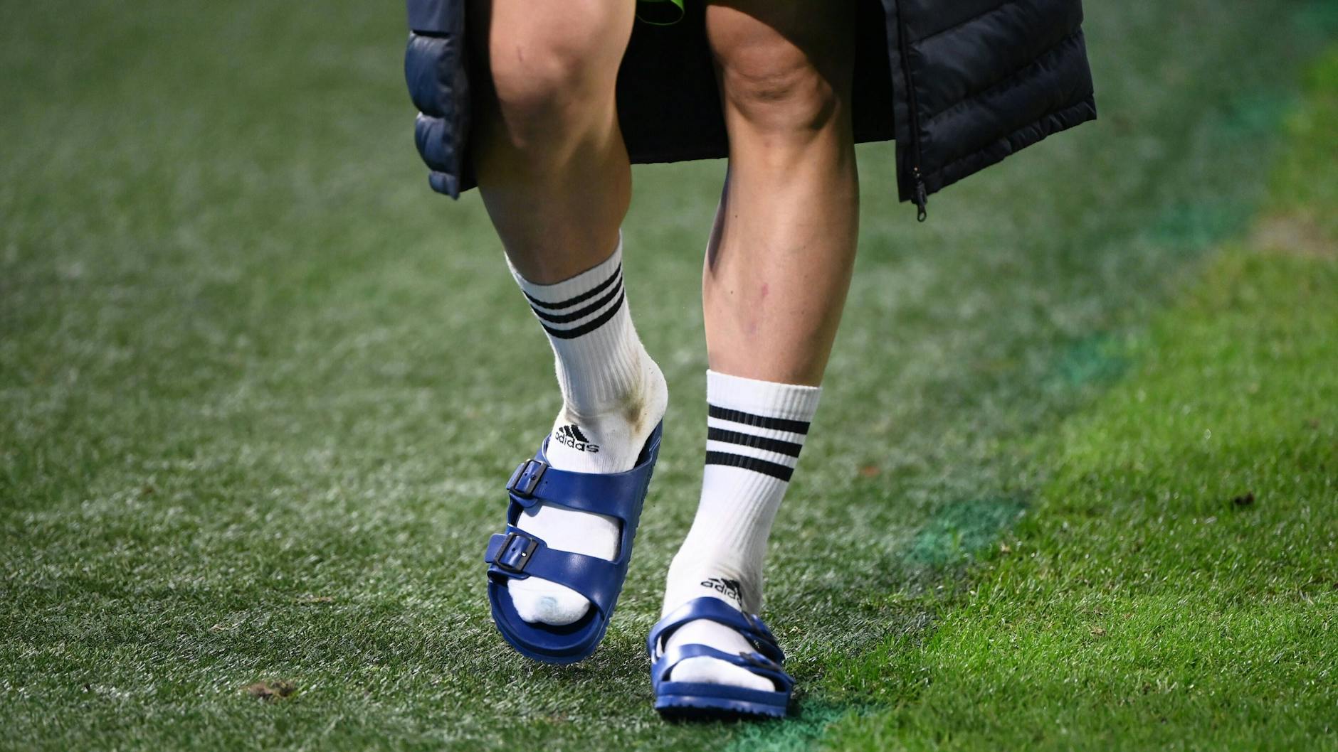 Was an Fußballerwaden einen hippen Abschluss bildet, sieht an deutschen Männern in der Regel zum Davonlaufen aus: Socken in Adiletten.