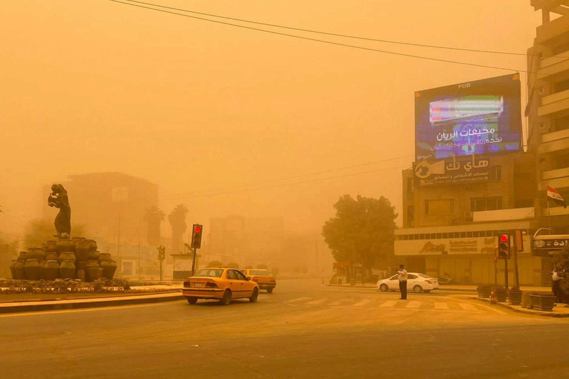 Autos in Bagdad fahren durch einen Sandsturm.