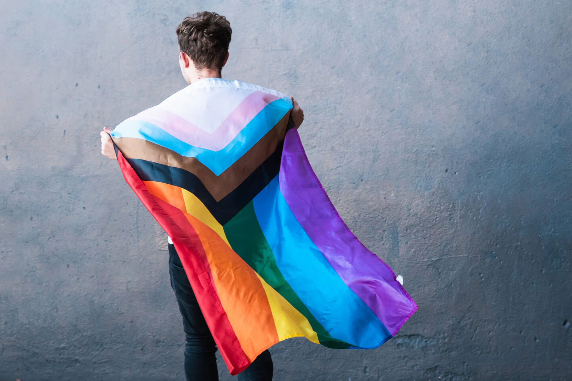 Die „Progressive Pride Flag“ zeigt die Regenbogenfarben, Weiß, Rosa und Hellblau aus der Trans-Flagge und Braun und Schwarz für Menschen of Colour.