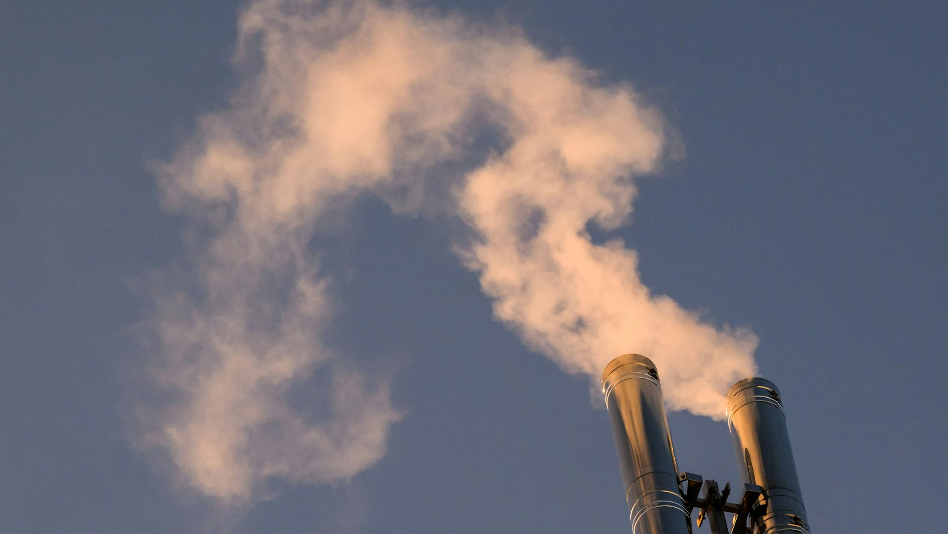 Rauch steigt aus Schornsteinen einer Heizung eines Mehrfamilienhauses auf.