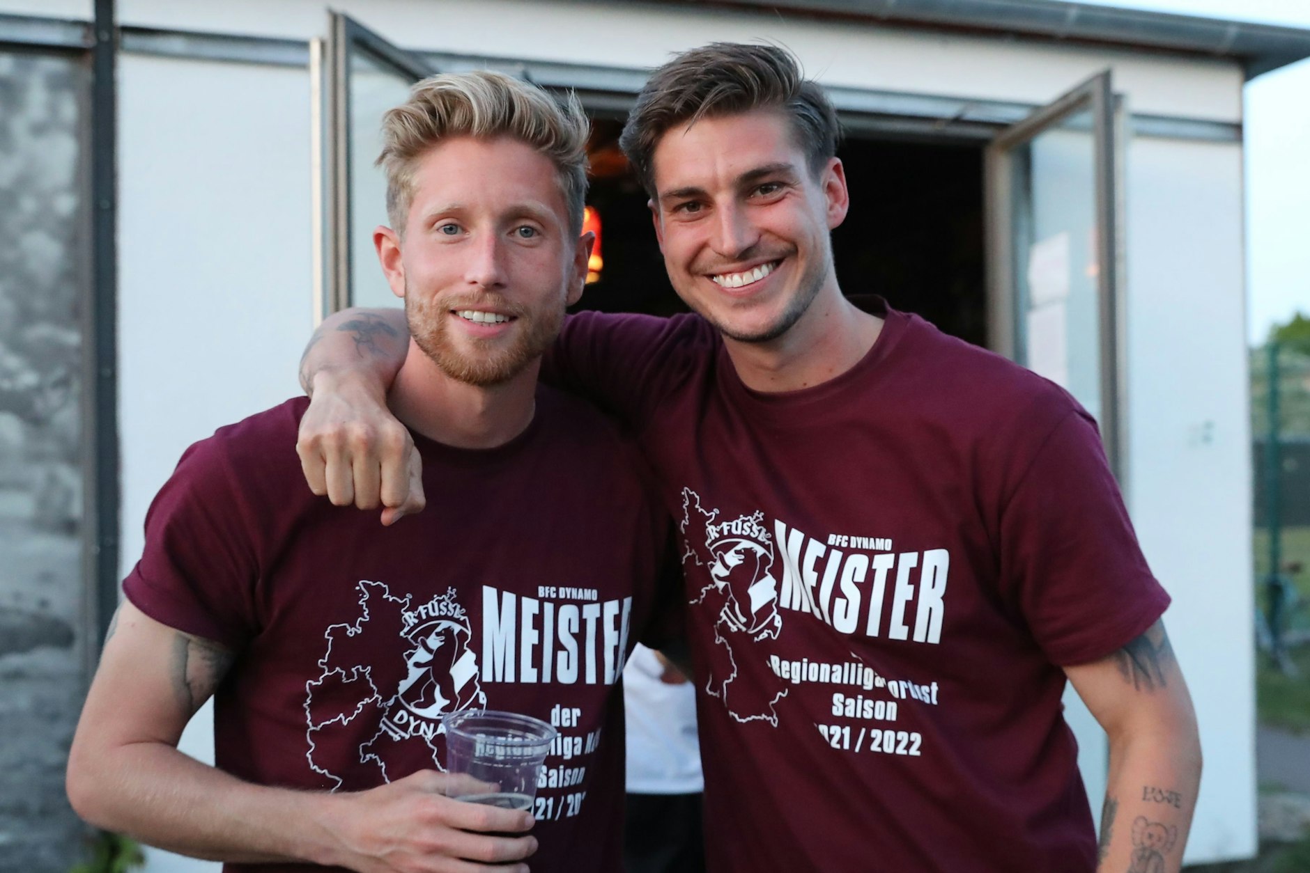 Die BFC-Kicker Sebastian Hertner (l.) und Andor Bolyki tragen das exklusive Meister-T-Shirt sichtlich mit Stolz. Jetzt kann es auch der Fan erwerben und so etwas gegen die Liquiditätslücke tun.