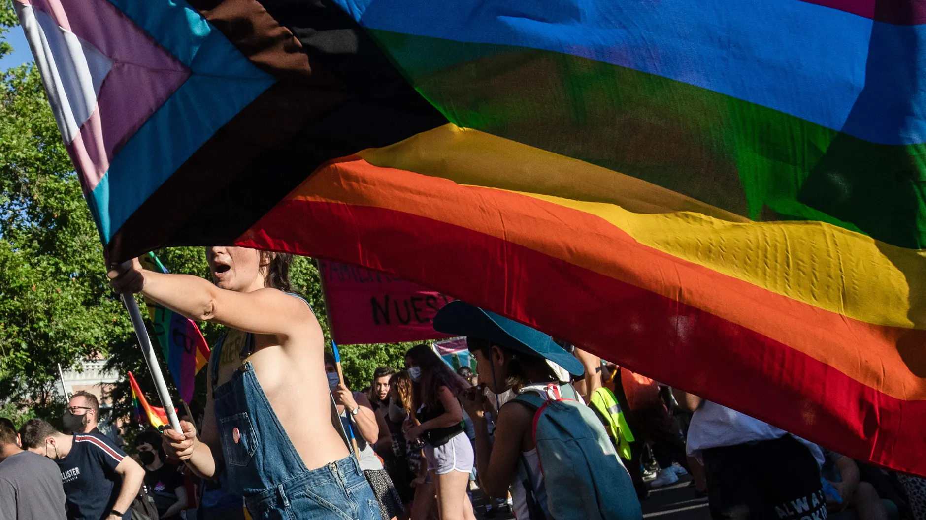 Eine junge Frau schwenkt eine Pride-Fahne. (Symbolbild)