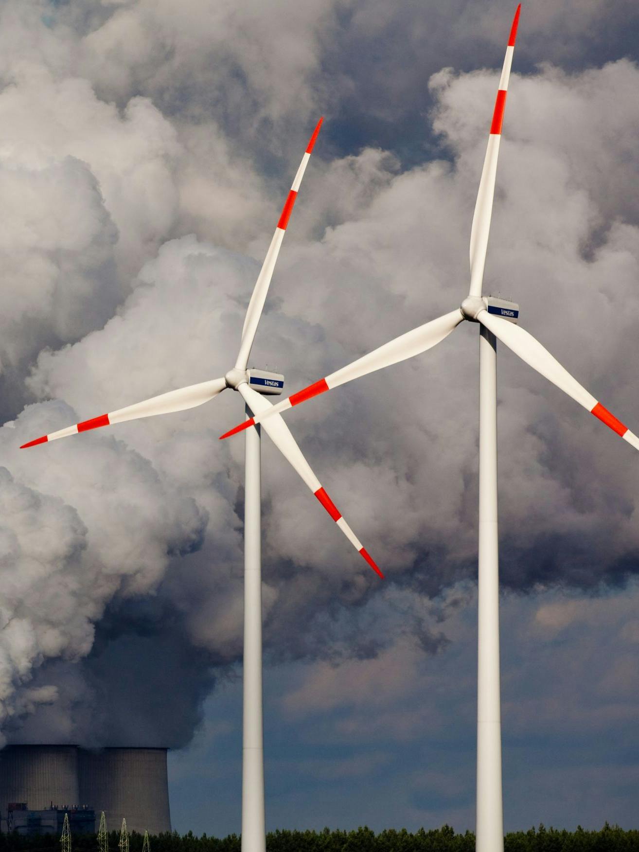 Weiter wie bisher ist keine Lösung: Windräder drehen sich vor den Kühltürmen des Braunkohlekraftwerks im brandenburgischen Jänschwalde.