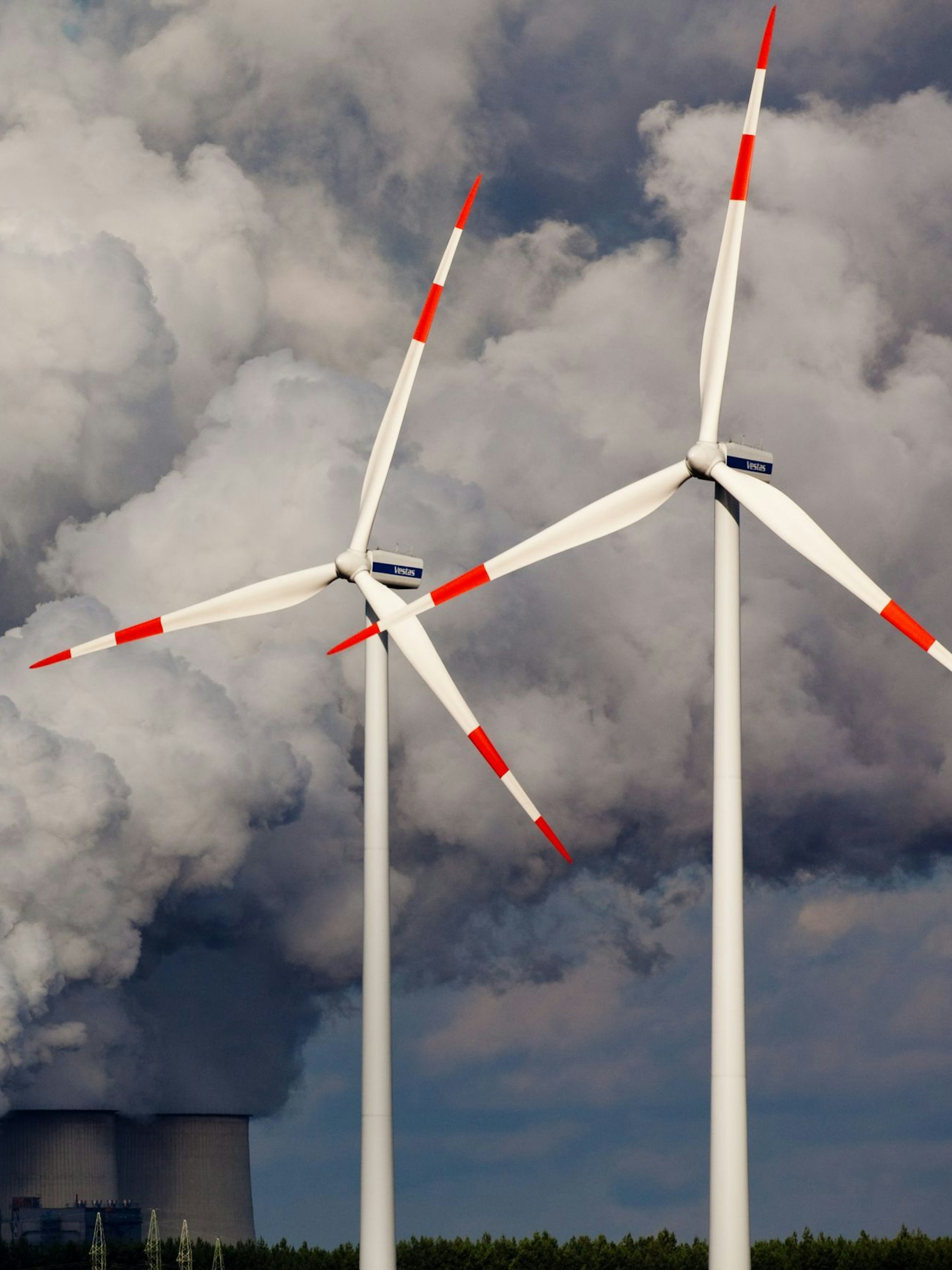 Weiter wie bisher ist keine Lösung: Windräder drehen sich vor den Kühltürmen des Braunkohlekraftwerks im brandenburgischen Jänschwalde.