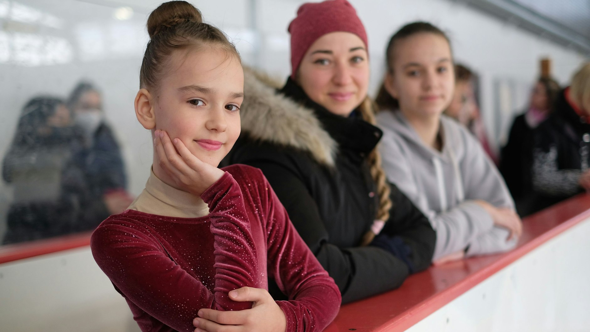 Die ukrainischen Eiskunstläuferinnen Arina und Polina Varnavska nehmen ihre Trainerin Anastasia Honcharova, die gleichzeitig ihre Tante ist, in ihre Mitte.