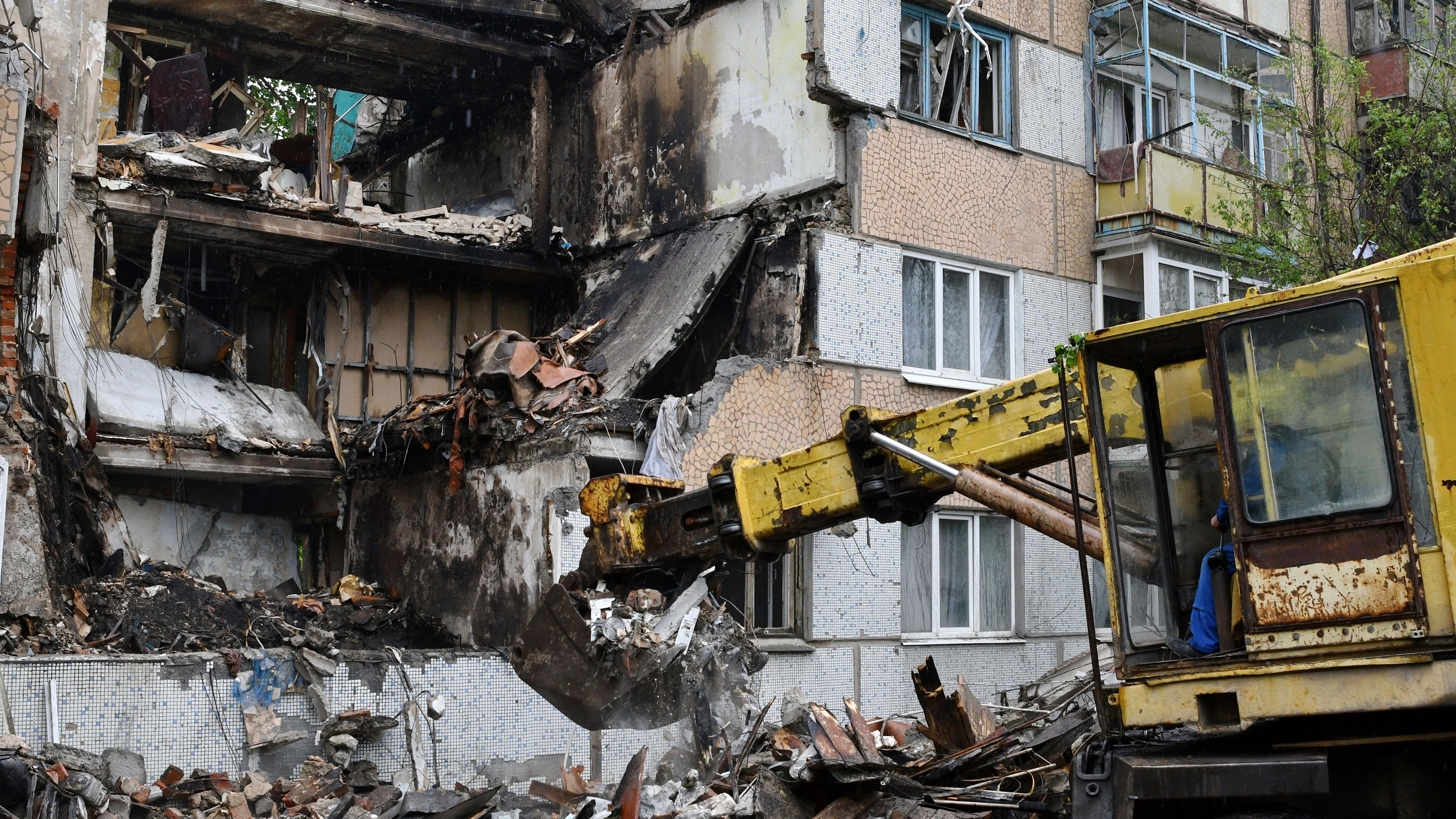 Nach einem Beschuss durch russische Truppen. Bagger bei Aufräumarbeiten in der Stadt Bachmut.