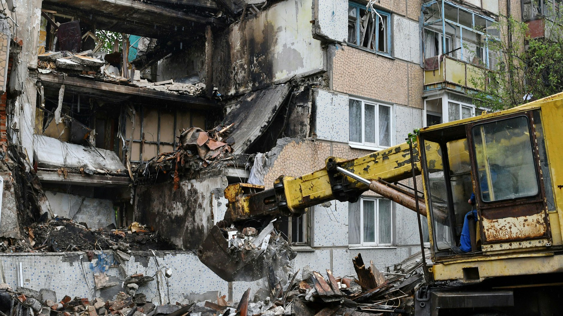 Nach einem Beschuss durch russische Truppen. Bagger bei Aufräumarbeiten in der Stadt Bachmut.
