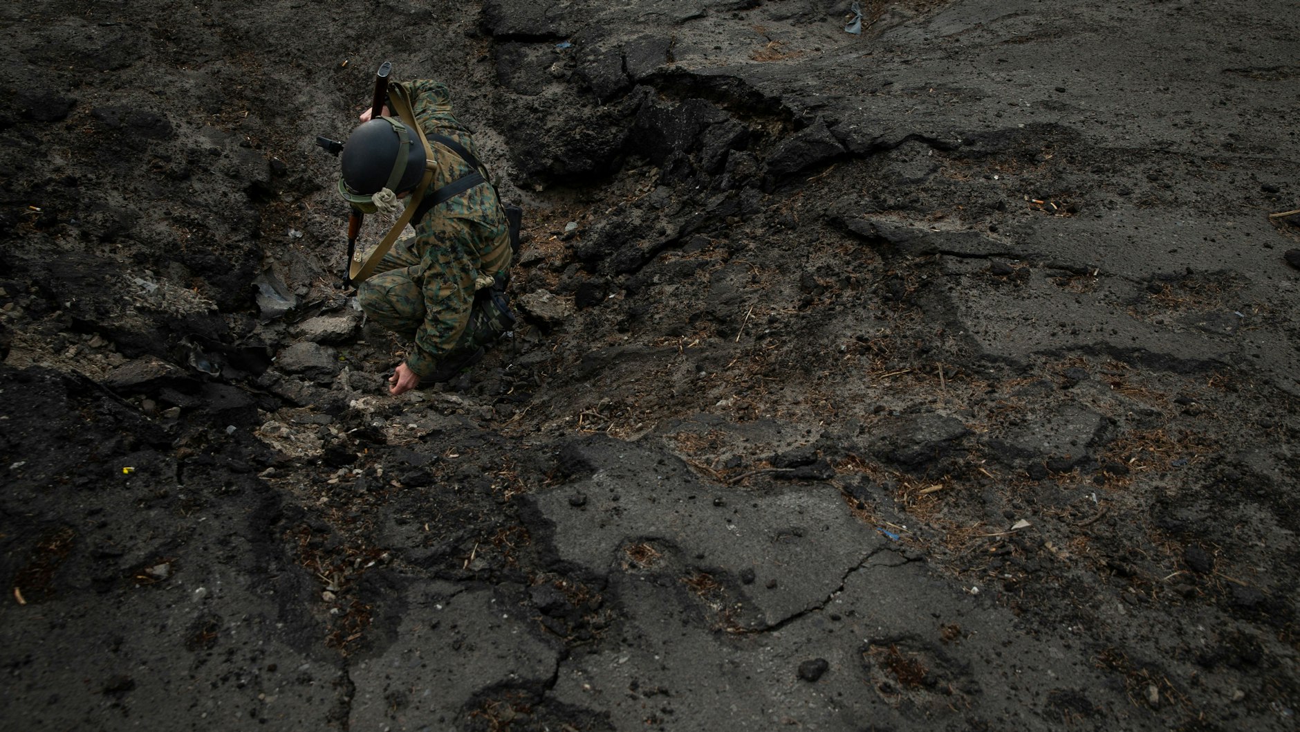 Der altgediente Soldat Aaron hebt einen Teil einer explodierten Granate auf, um sie dem neuen Rekruten Yost (nicht im Bild) zu zeigen. 