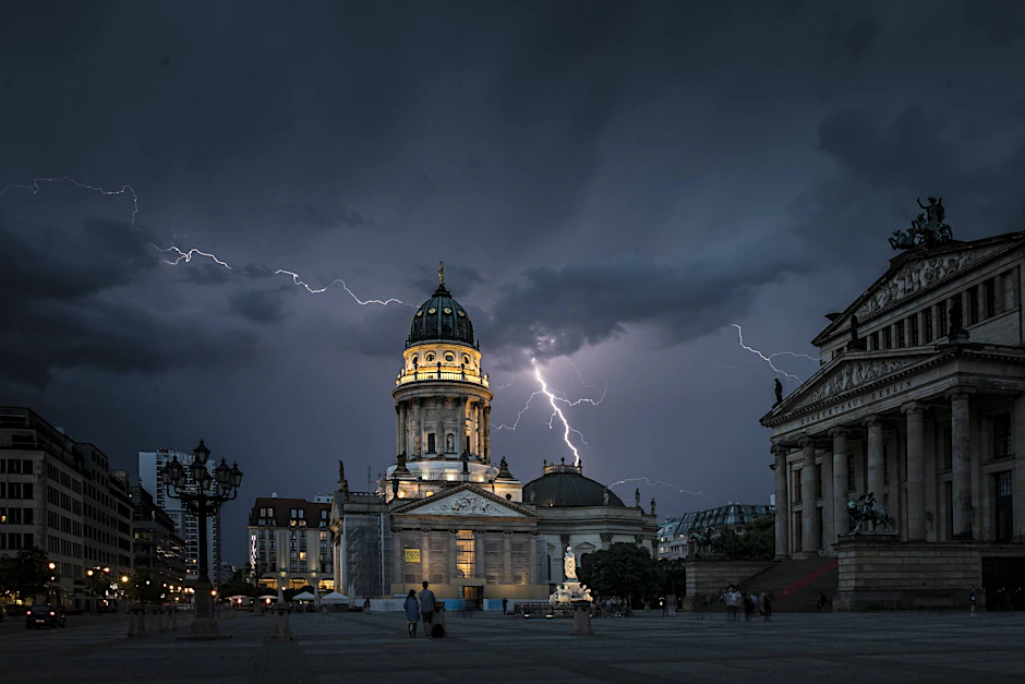 Blitze zeichnen sich während eines Unwetters über dem Berliner Konzerthaus und dem Deutschen Dom auf dem Gendarmenmarkt ab. Auch am Freitag kann es wieder heftige Gewitter in Berlin geben.