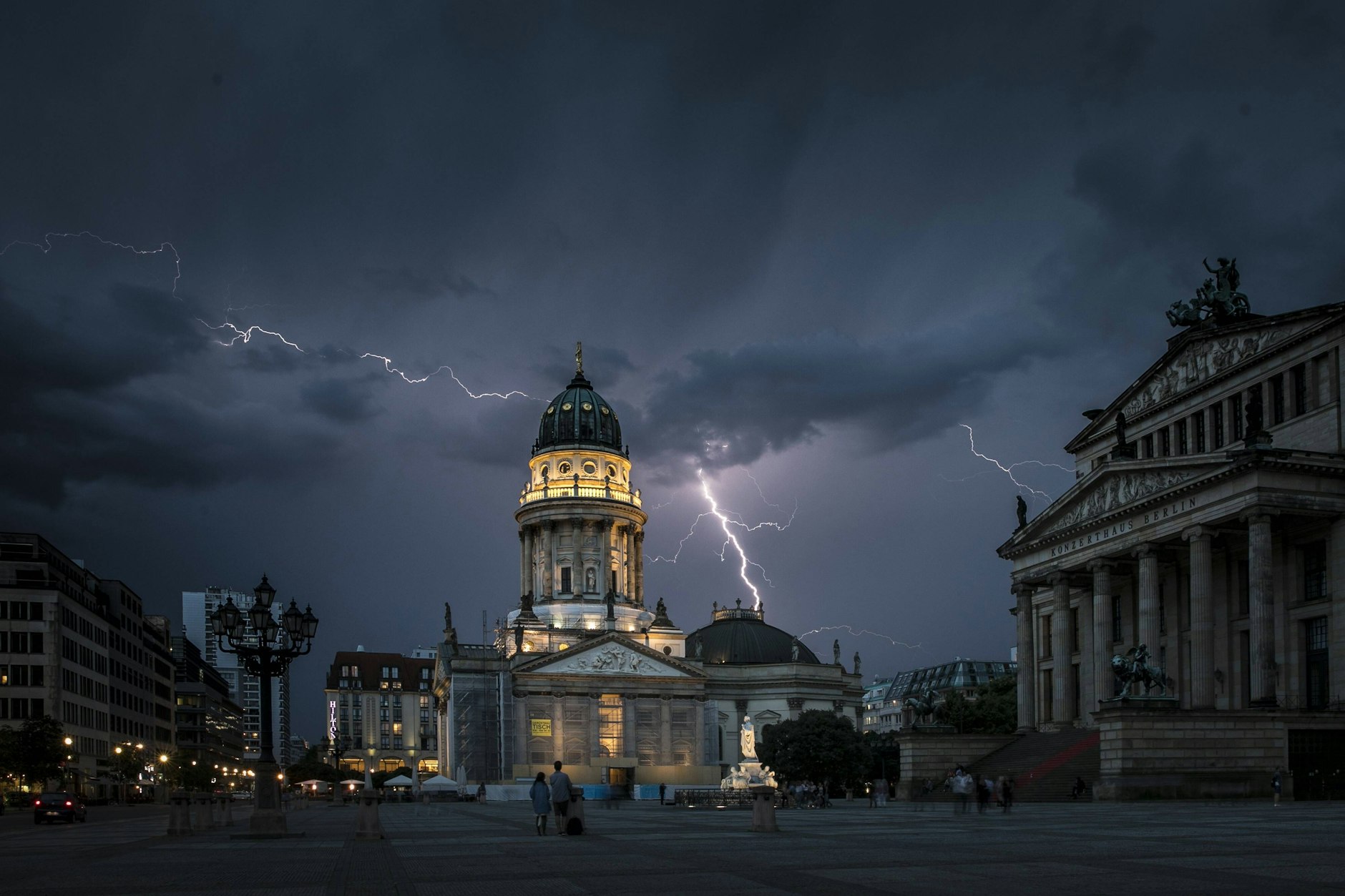 Blitze zeichnen sich während eines Unwetters über dem Berliner Konzerthaus und dem Deutschen Dom auf dem Gendarmenmarkt ab. Auch am Freitag kann es wieder heftige Gewitter in Berlin geben.