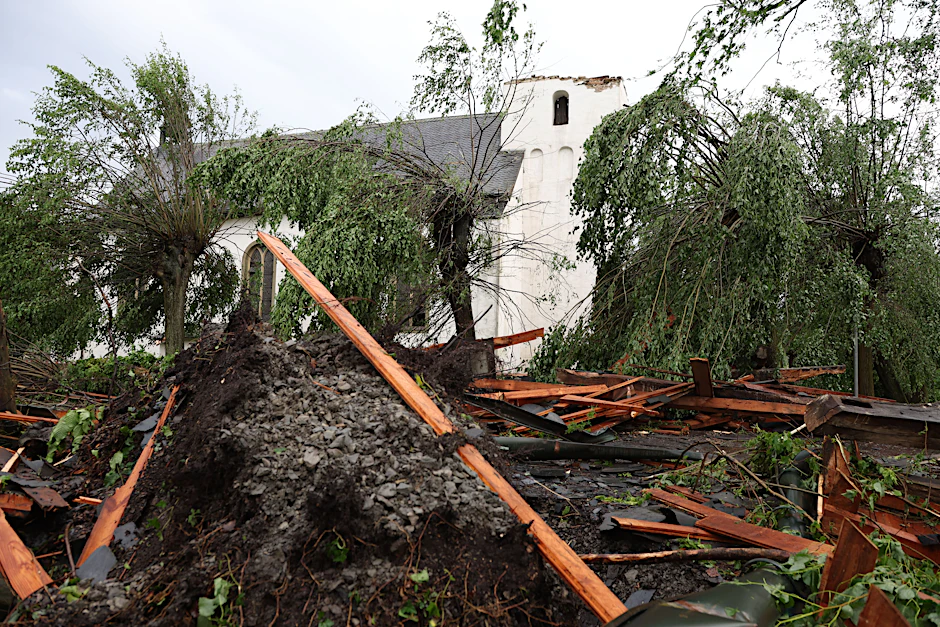 Trümmer liegen vor der katholischen Kirche St. Clemens in Hellinghausen bei Lippstadt, deren Spitze zerstört wurde. Ein mutmaßlicher Tornado hat in Lippstadt am Freitagnachmittag massive Schäden verursacht.