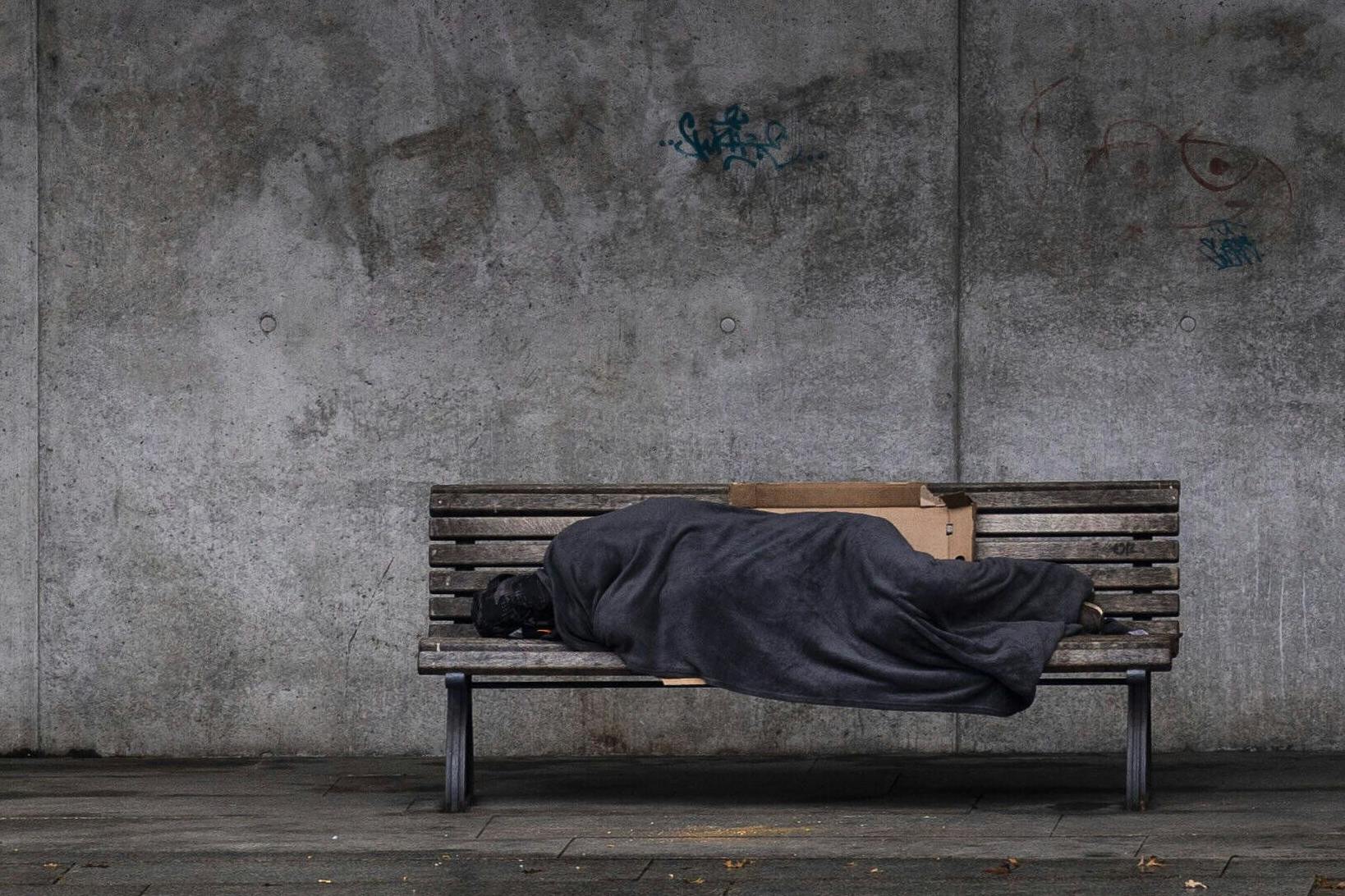 Ein Obdachloser auf einer Bank in Berlin.