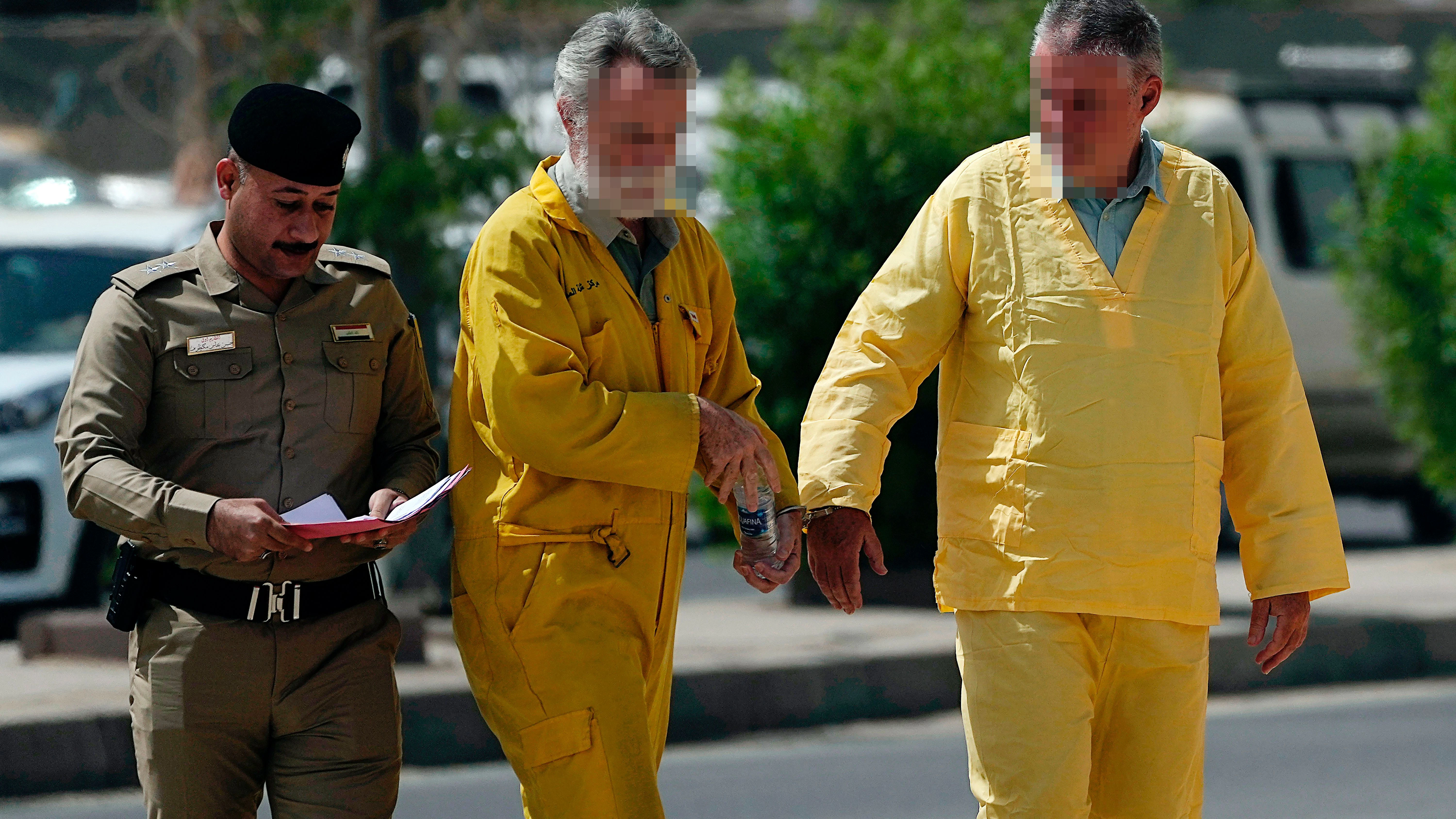 Der Berliner Volker W. (r.) und der Brite Jim F. werden in Bagdad in Handschellen in einen Gerichtssaal geführt. Beide gaben an, ihnen sei das Gesetz über den Schmuggel von Antiquitäten nicht bekannt gewesen.