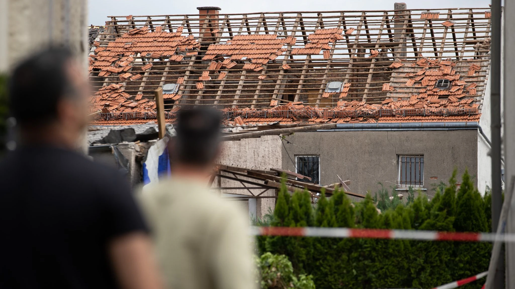 Anwohner blicken auf das beschädigte Dach eines Hauses in Lippstadt. Er Tornado hatte dort am Freitag für Verwüstung gesorgt.