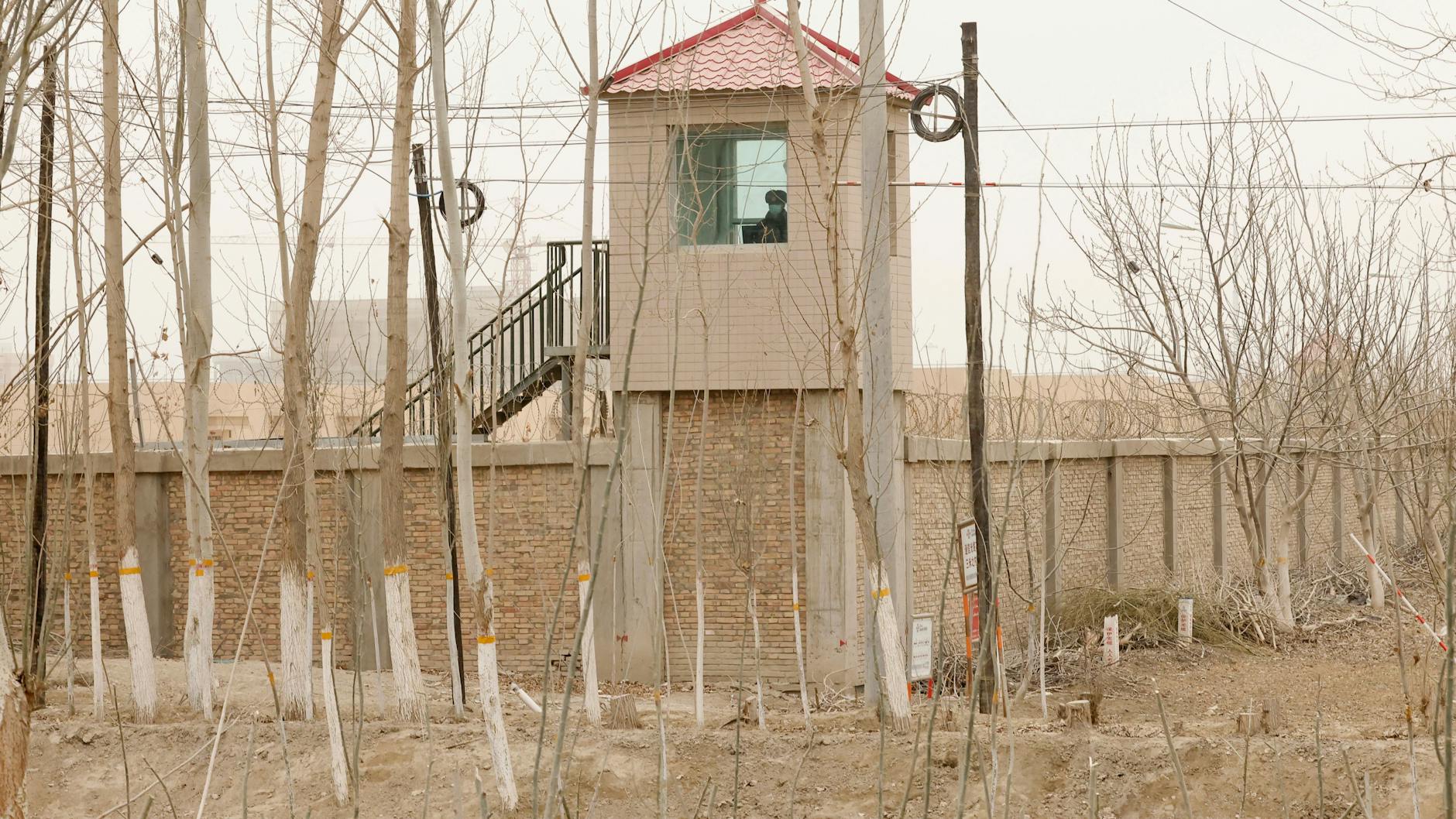 Ein Sicherheitsbeamter beobachtet von einem Wachturm aus eine Haftanstalt der Region Xinjiang.